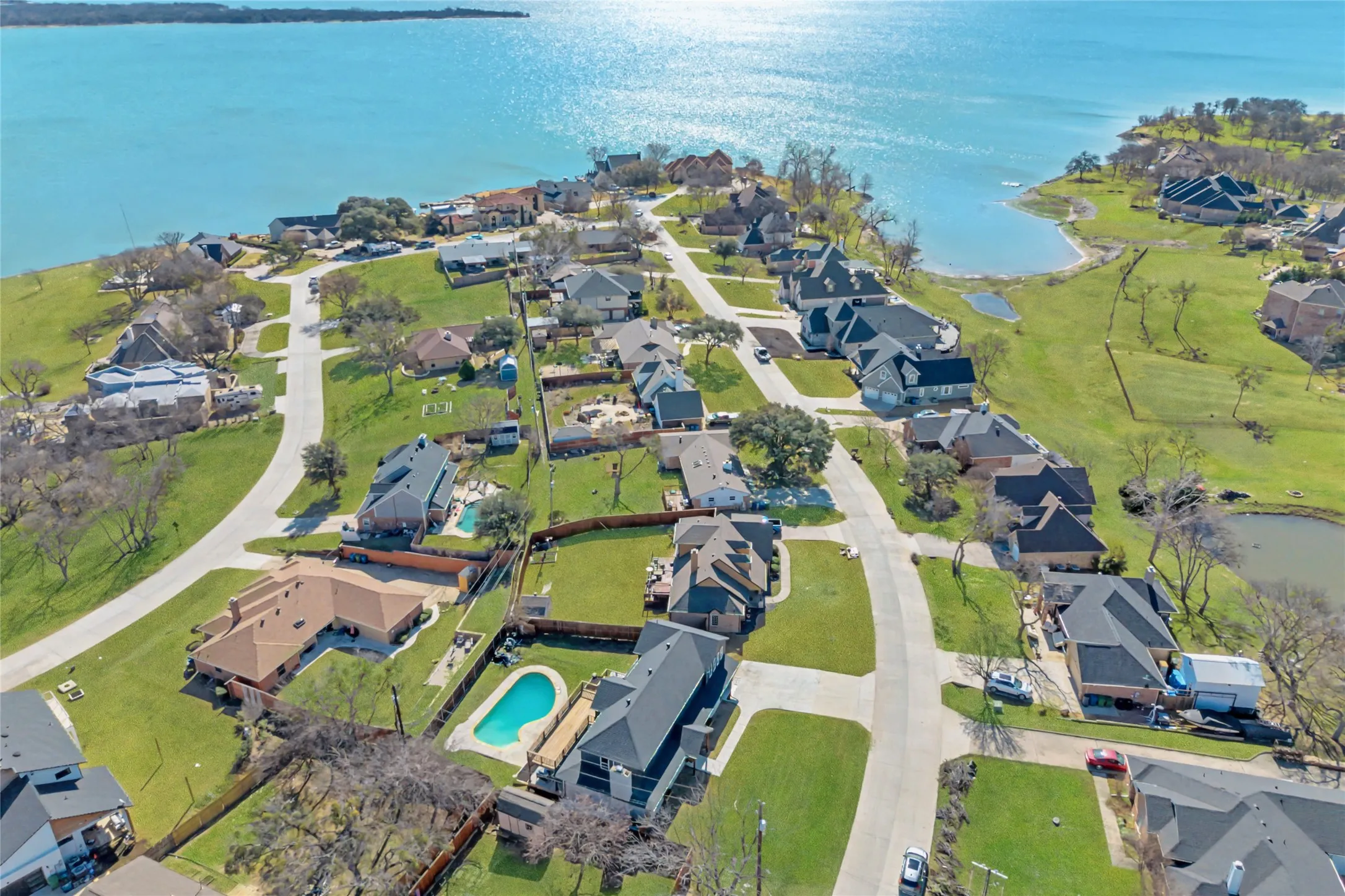 Aerial perspective showcasing a residential community with lake access