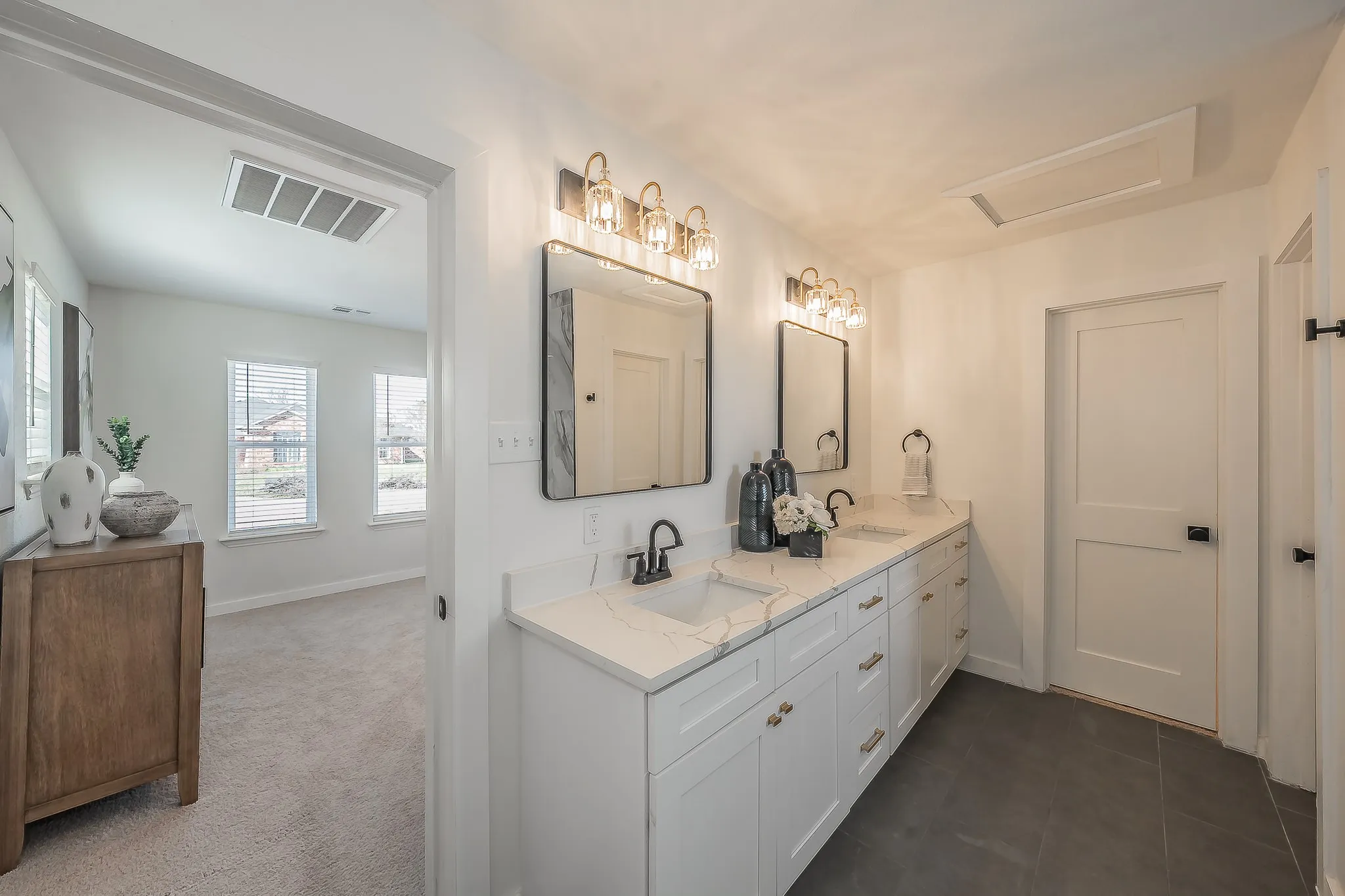 Double vanity with white cabinetry, gold-finish hardware, and marble-look countertops