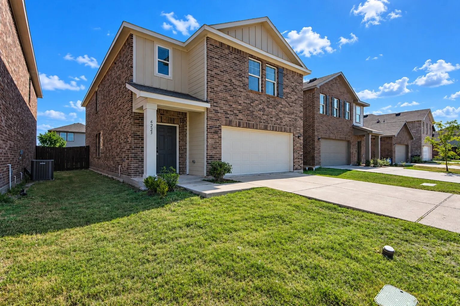 Two-story residence featuring a brick exterior and gabled roofline