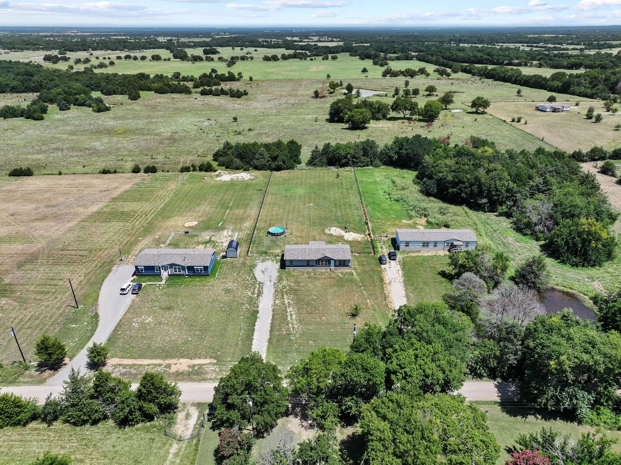 Expansive rural landscape featuring multiple residential structures and extensive open land