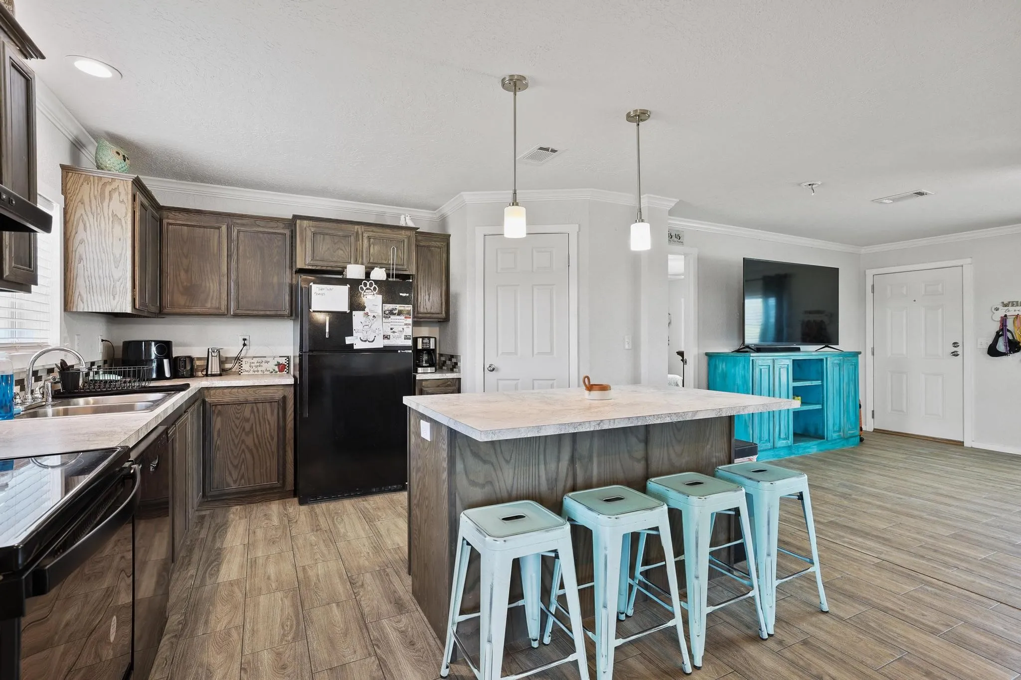 Kitchen featuring wood-finish flooring, dark wood cabinetry, and an island with a light-toned countertop