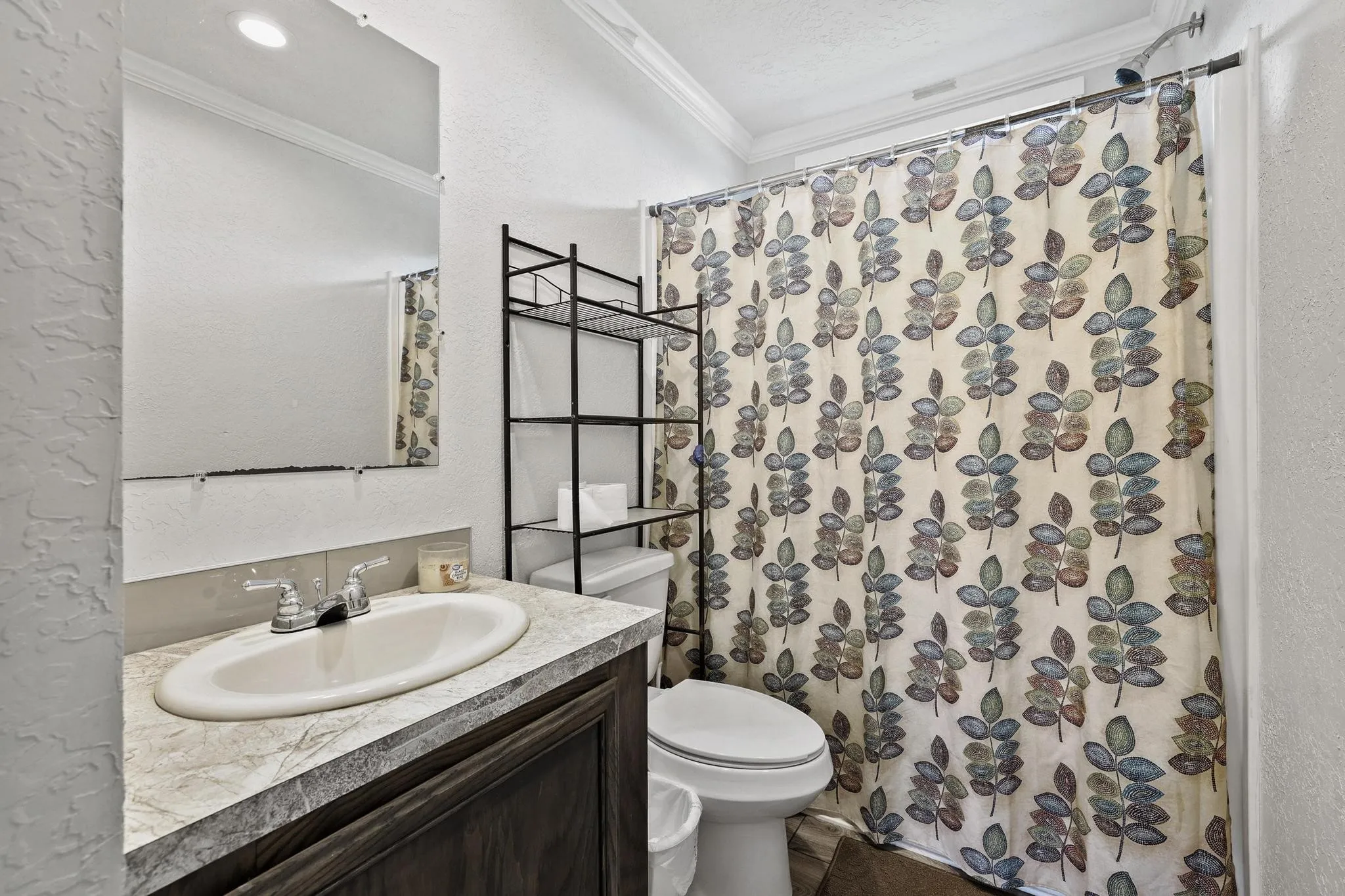 Bathroom vanity featuring an integrated sink, laminate countertop, and wood-finish cabinetry