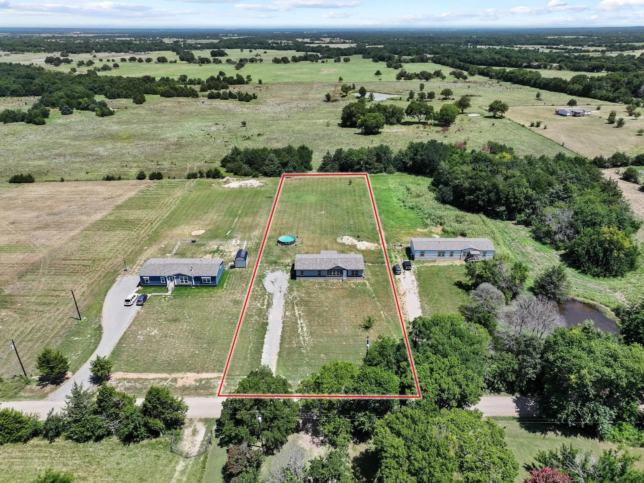 Expansive land parcel featuring open fields and distant tree lines