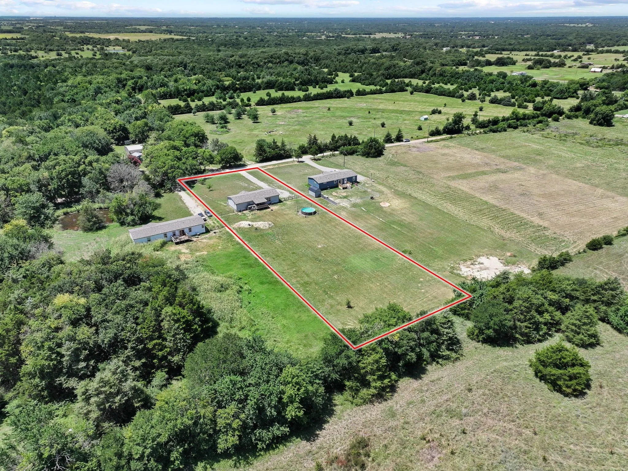 Expansive property featuring two residential structures and a large open field