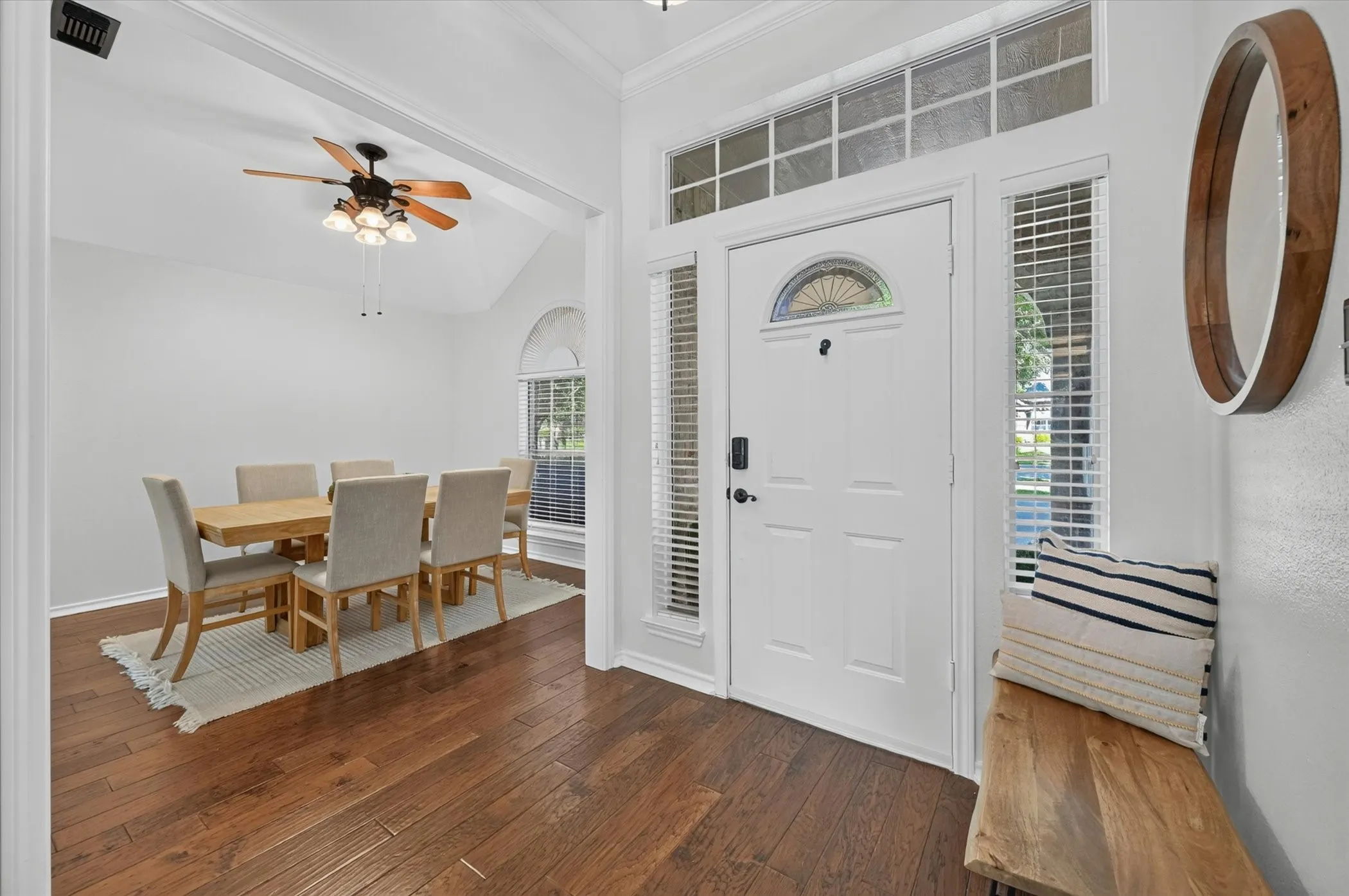 Entryway featuring wood-finish flooring, a white front door with decorative glass, and sidelight windows with blinds