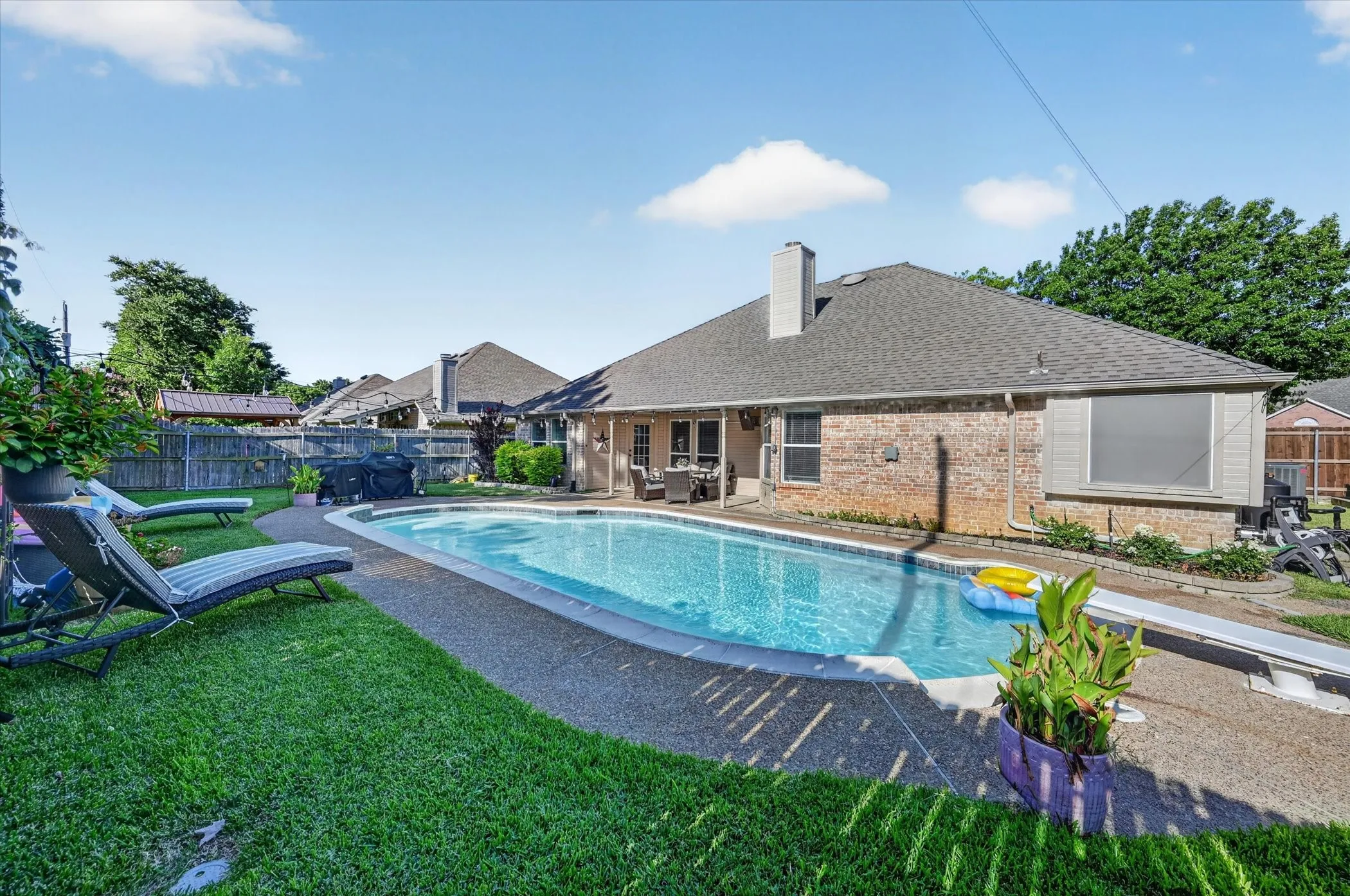 Backyard featuring a rectangular swimming pool with a concrete surround