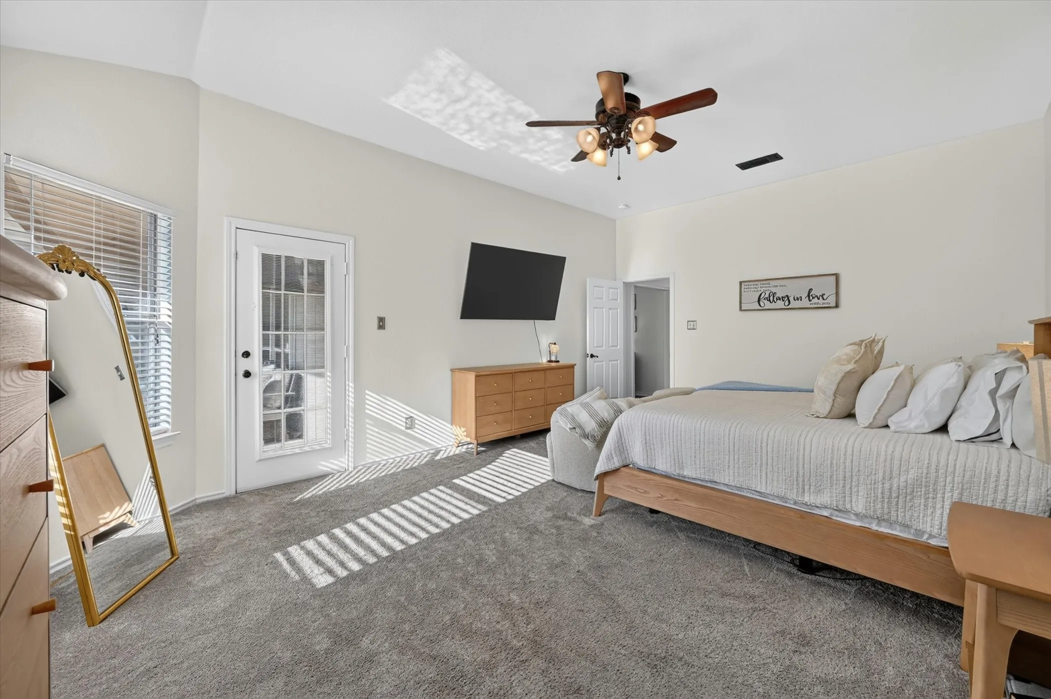 Spacious room featuring vaulted ceilings, a ceiling fan with integrated lighting, and plush carpeting