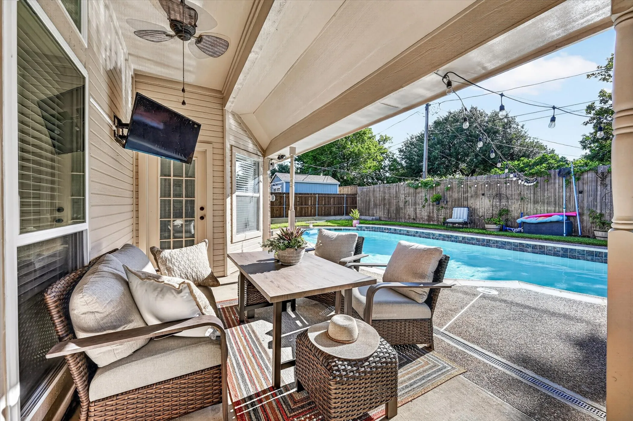 Covered outdoor patio featuring a ceiling fan, recessed lighting, and an attached television