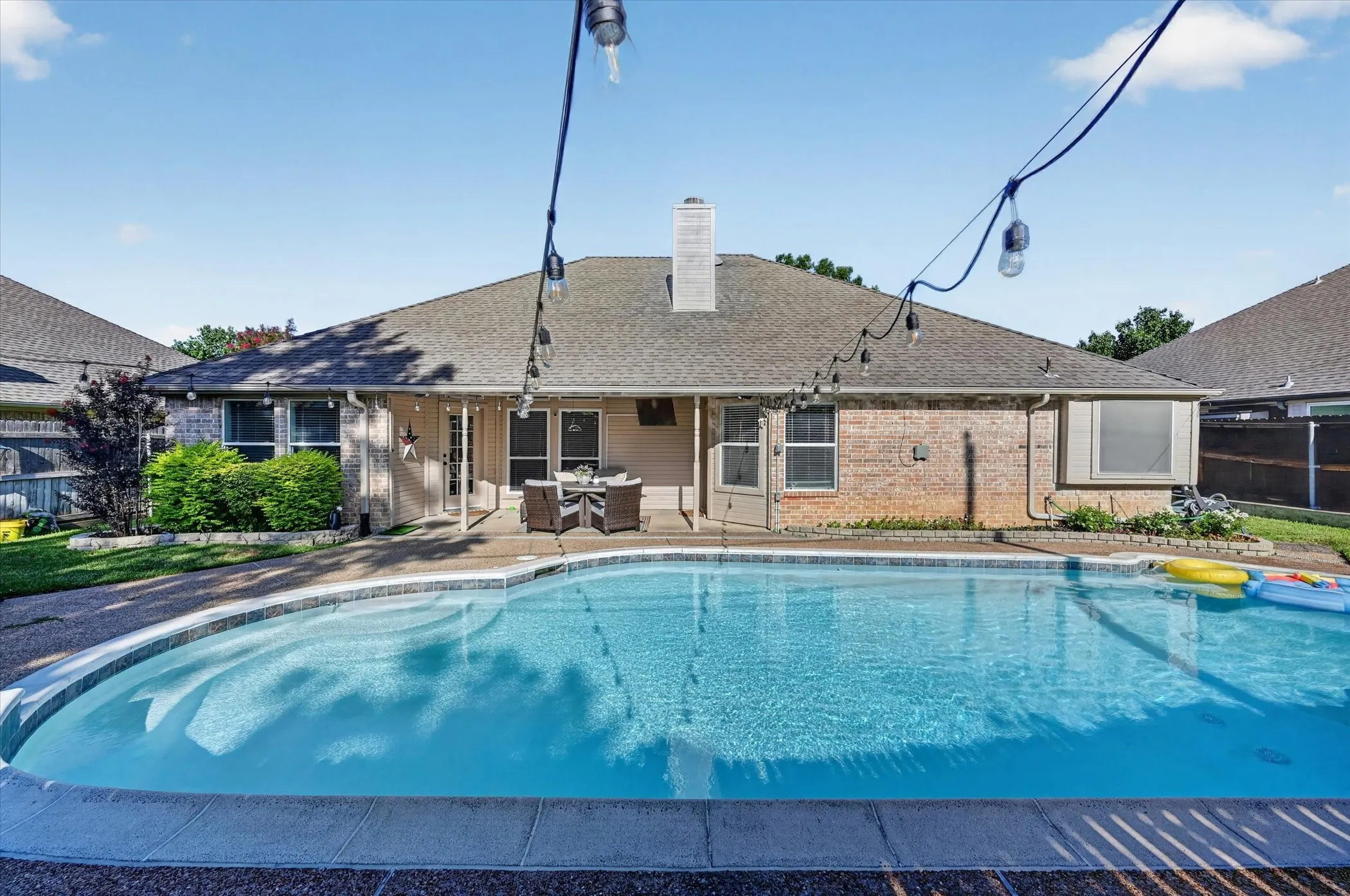 Shaped inground pool featuring a concrete surround