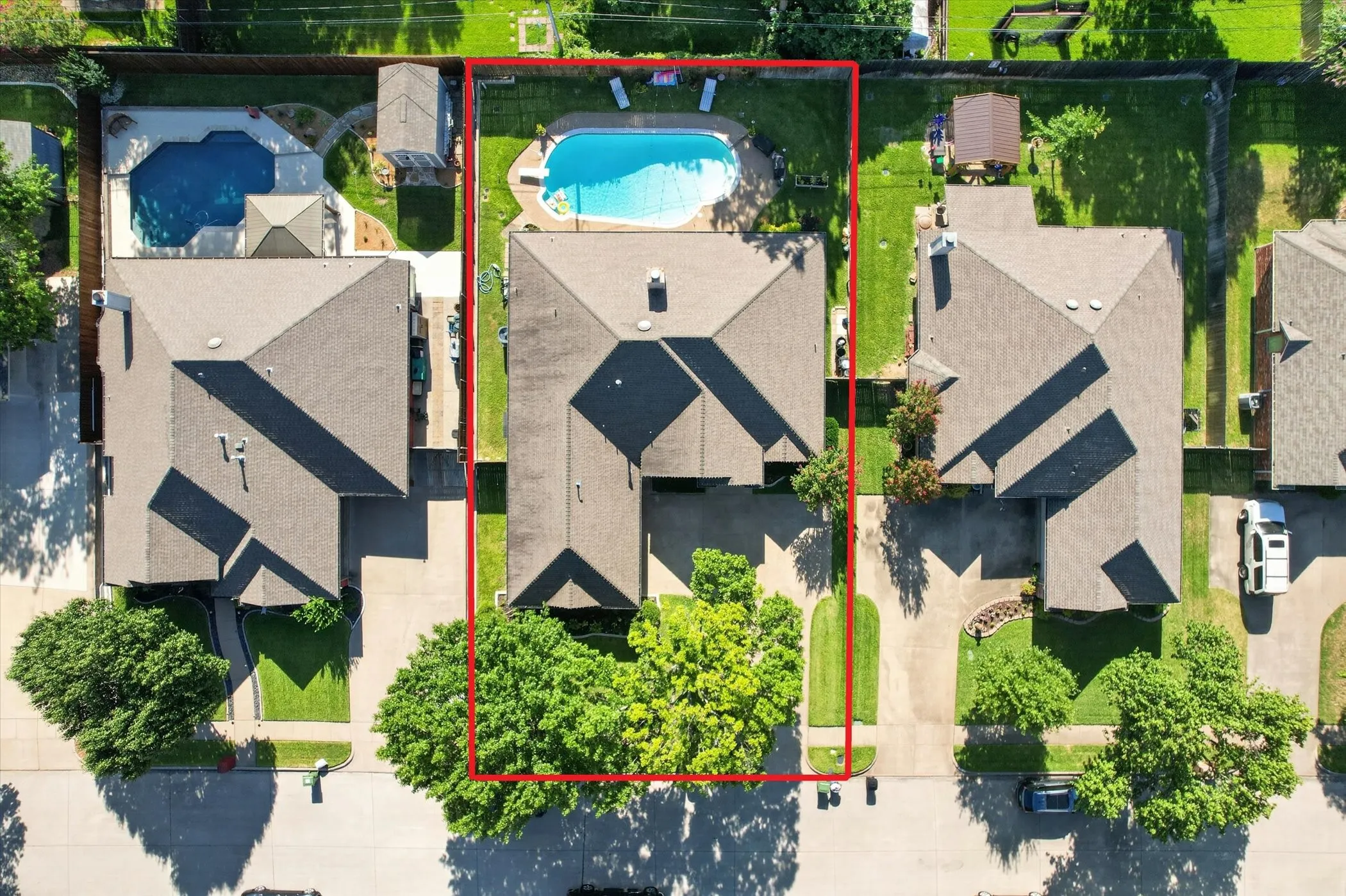 Expansive property featuring a central residence, a large private swimming pool, a spacious driveway, and mature landscaping