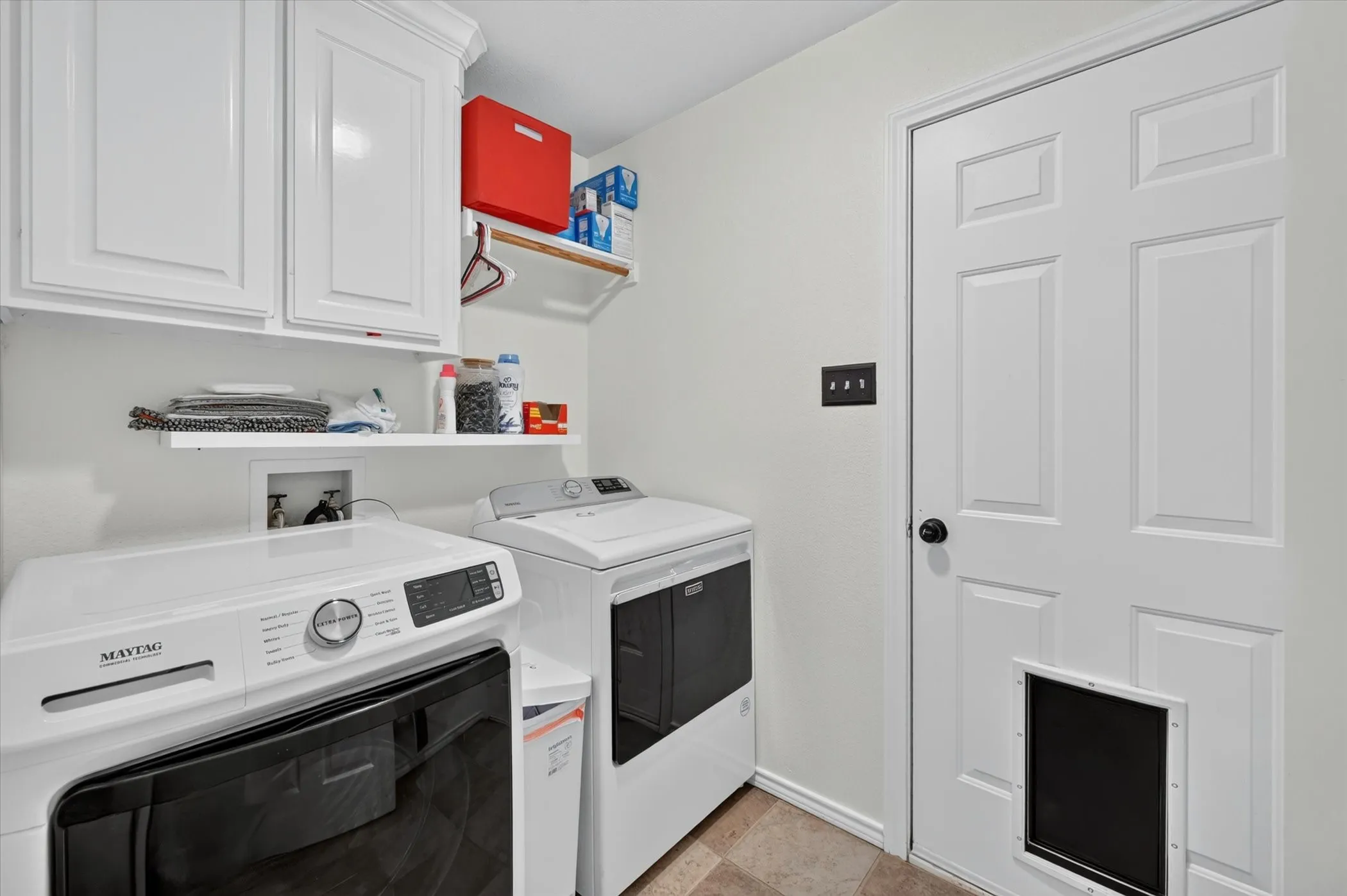 Laundry area featuring white cabinetry, a built-in shelf, and wood-finish flooring