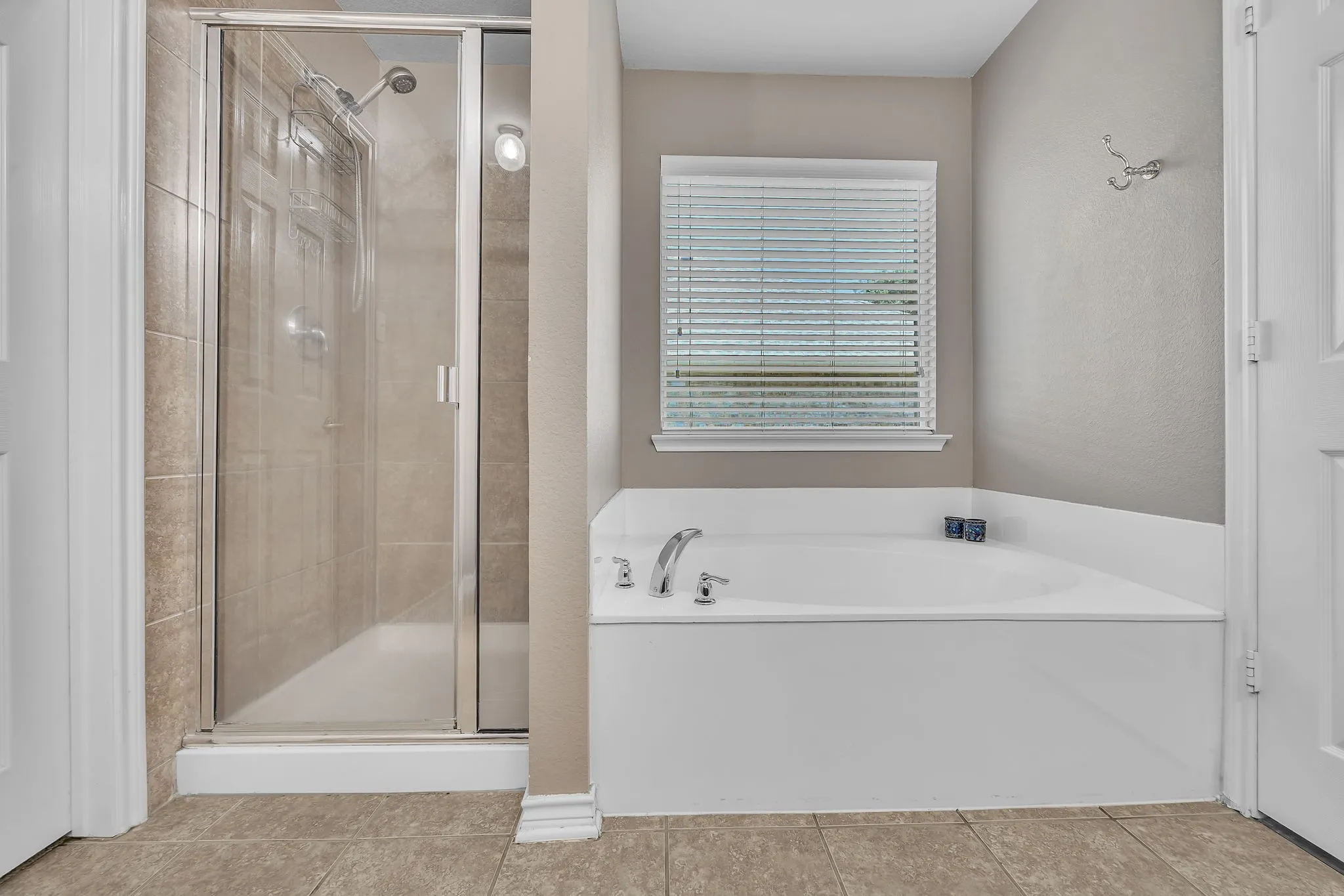 Walk-in shower with clear glass enclosure and tile surround