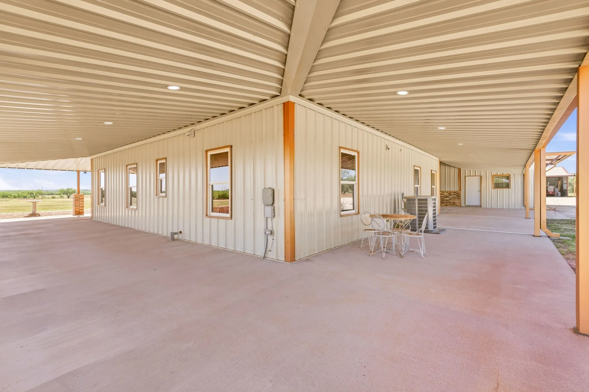 The wraparound porch continues around the side and back of the home, with a covered breezeway connecting the house and insulated shop under one continuous roofline- the kind of thoughtful design that makes everyday living, and big projects, that much easier.