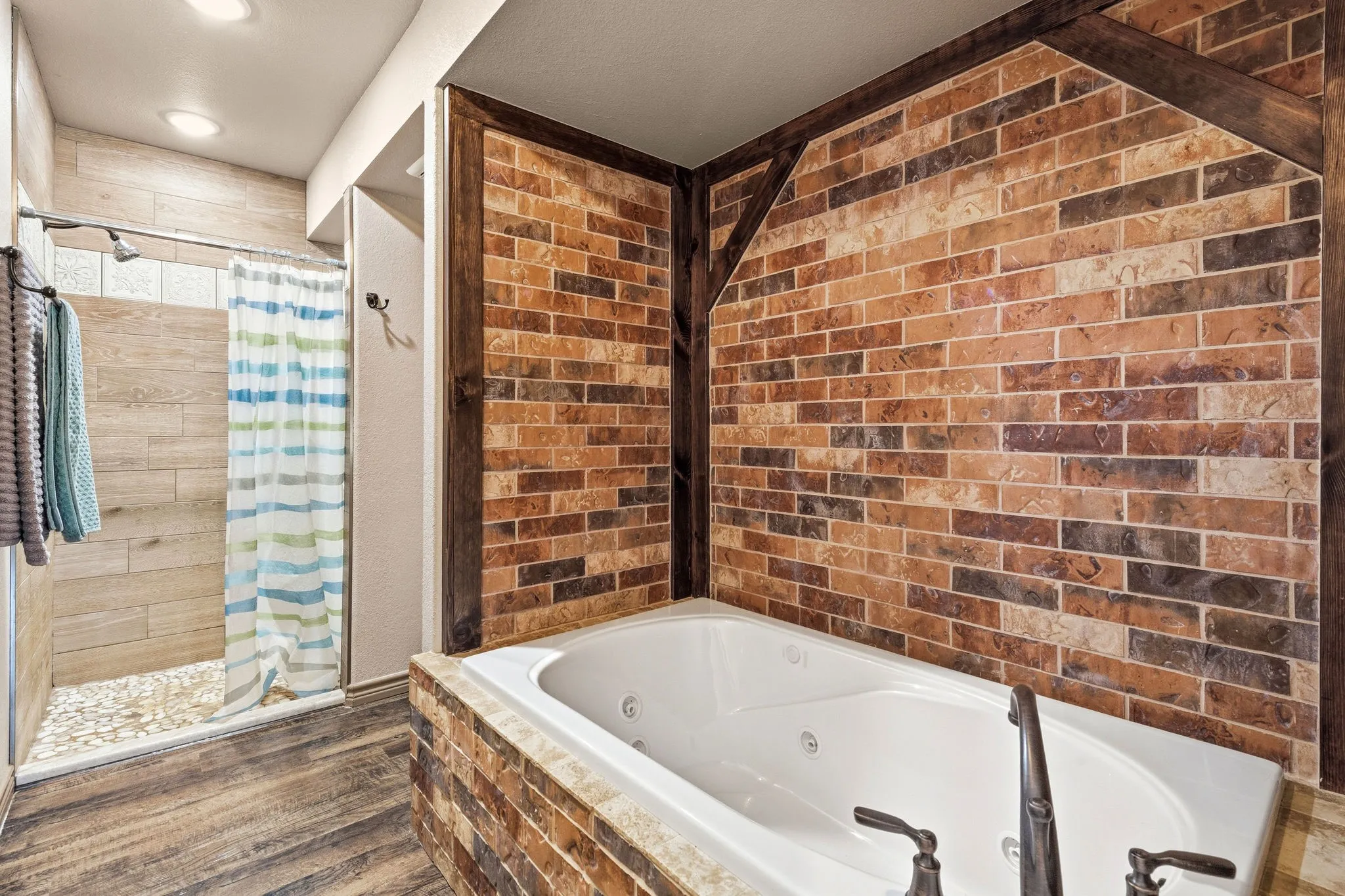 Sink into the jetted jacuzzi tub tucked into a stunning brick alcove, or rinse off in the separate standing shower just step away-a rustic, spa-like retreat built for unwinding after a long day.
