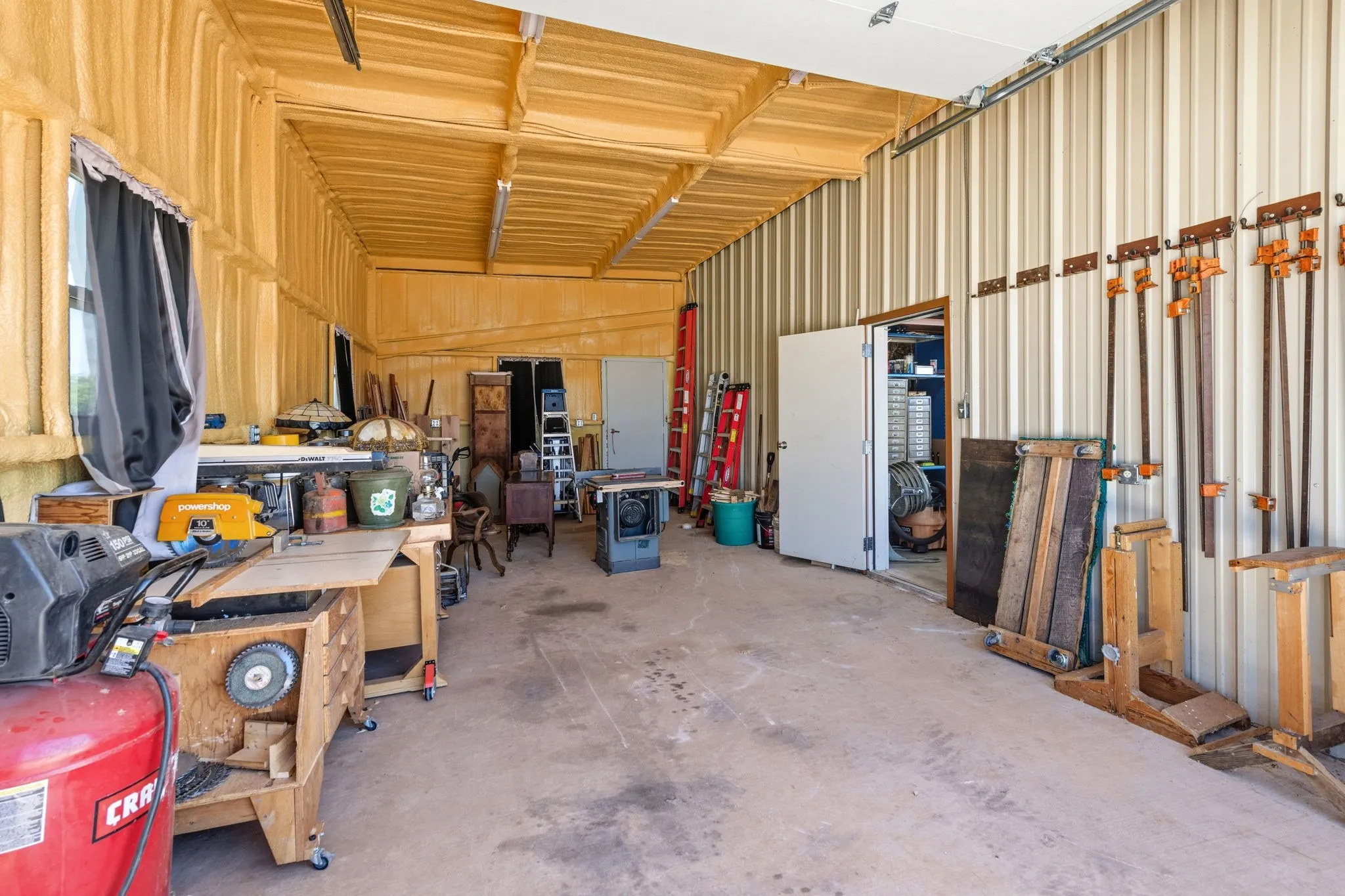 Another section of this versatile shop features its own bay door with a 12-foot clearance for larger vehicles, a 220 plug ready for heavy equipment, plus a covered area perfect for RV parking- space to fit it all.