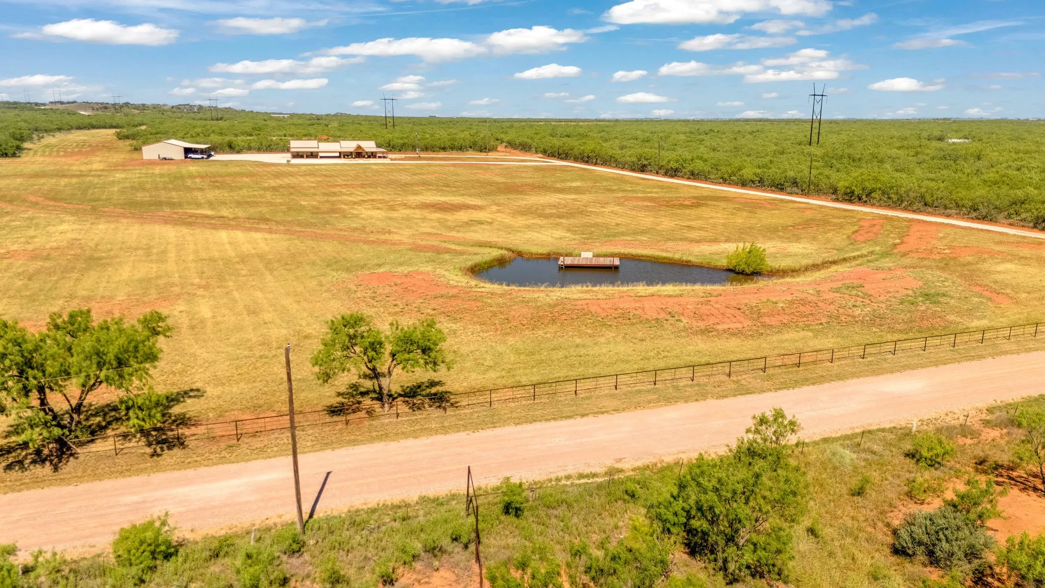 Pipe fencing along front of property along with impressive front entrance gate.  Tank with its own dock and roads cleared for easy travel around the property.