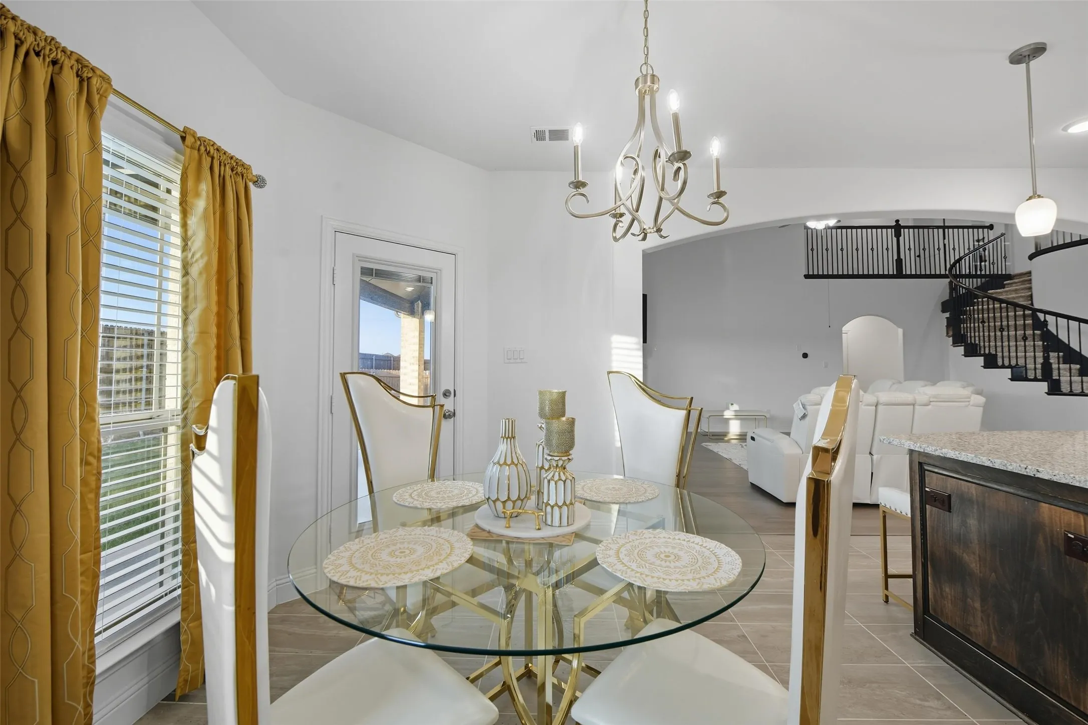 Dining area featuring a decorative chandelier, tile flooring, and a glass-top table