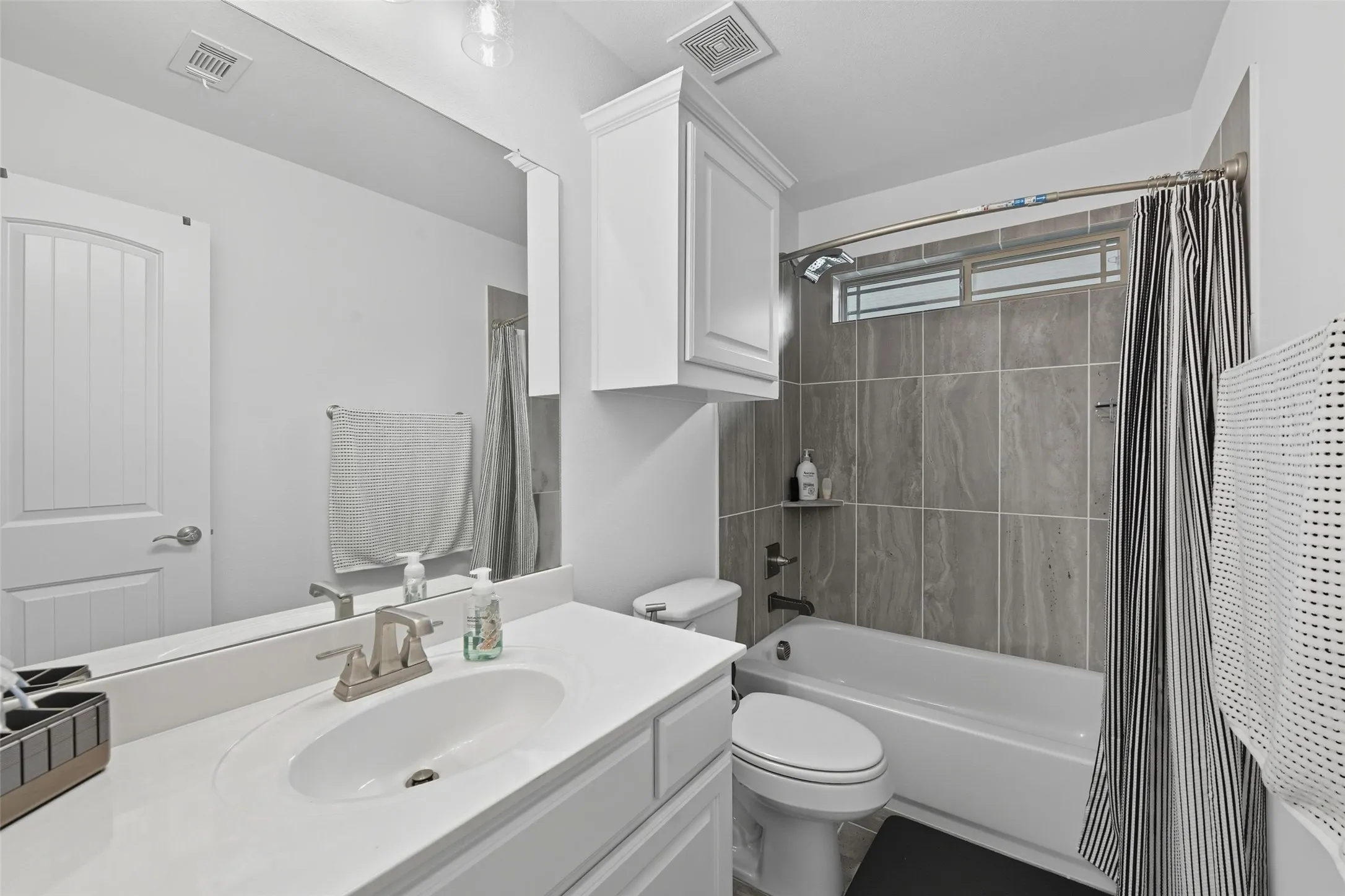 Bathroom featuring a white vanity with an undermount sink, brushed nickel faucet, and a large wall-mounted mirror
