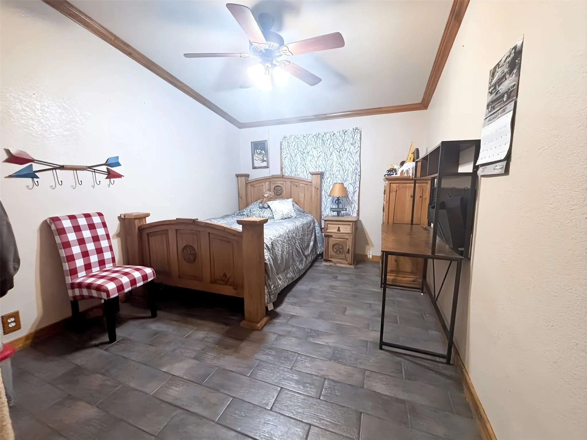 Room featuring wood-finish plank flooring, crown molding, and a ceiling fan with integrated lighting