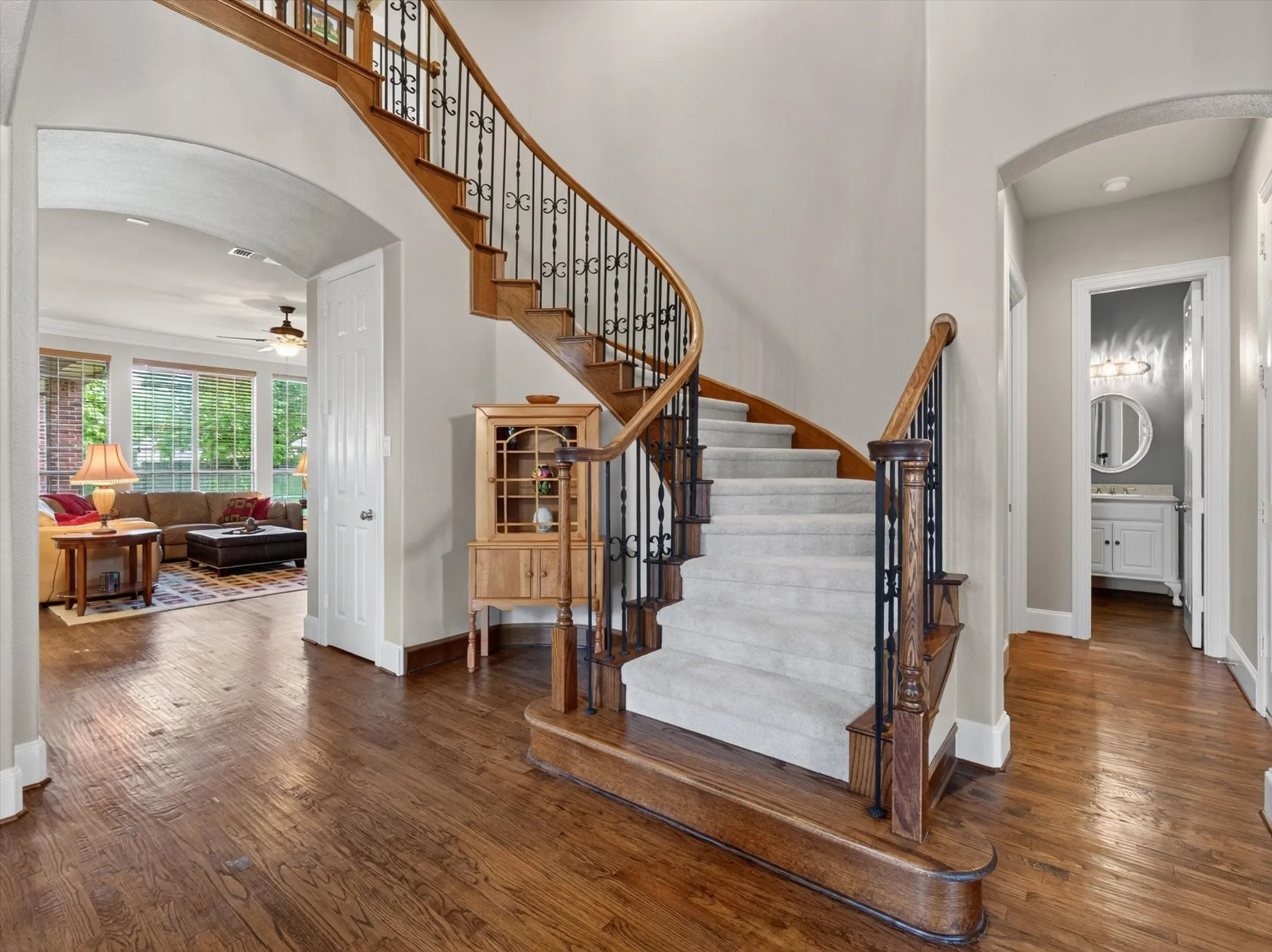 Winding staircase in foyer showcasing hard-wood floors