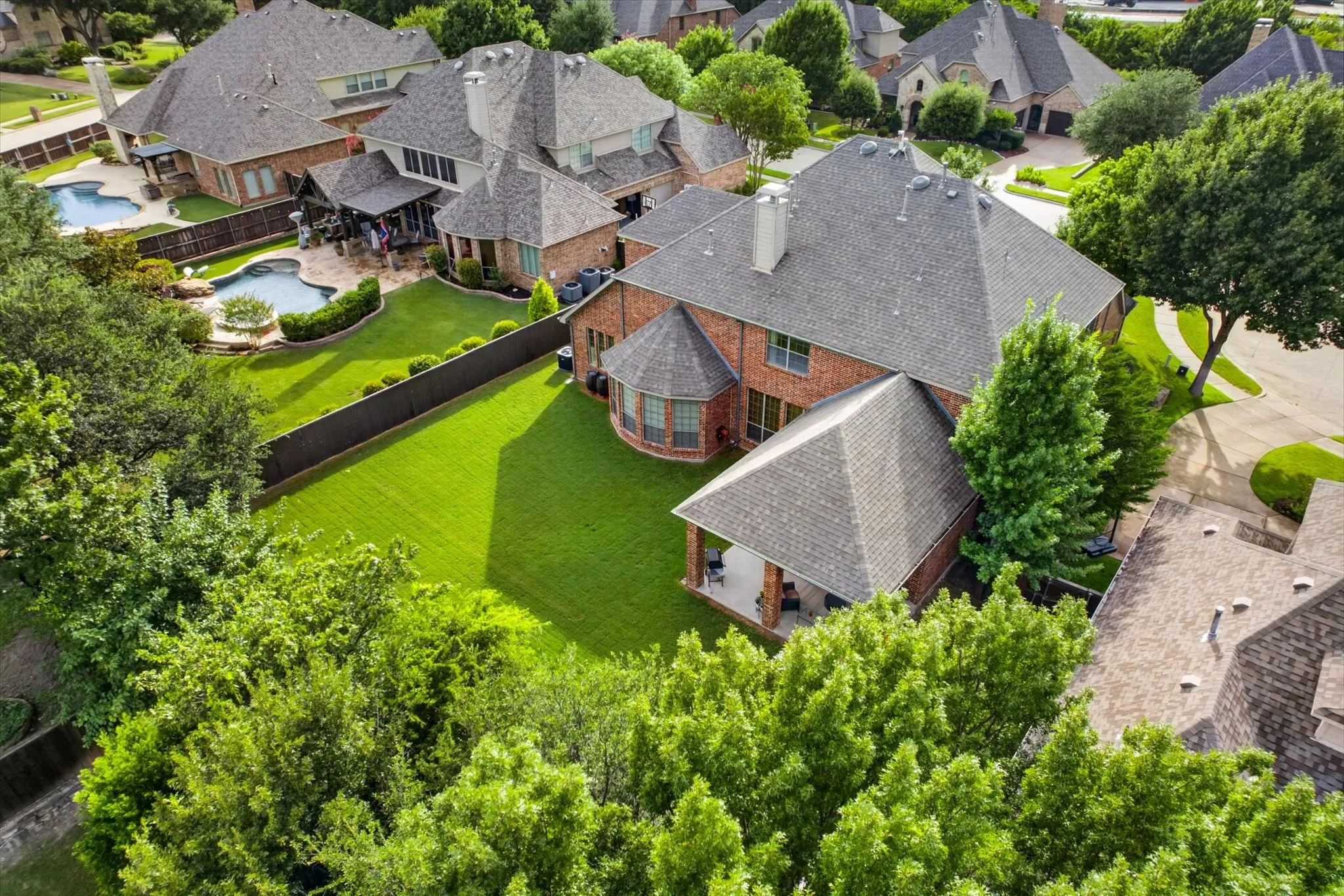 Pool-size backyard with mature trees.