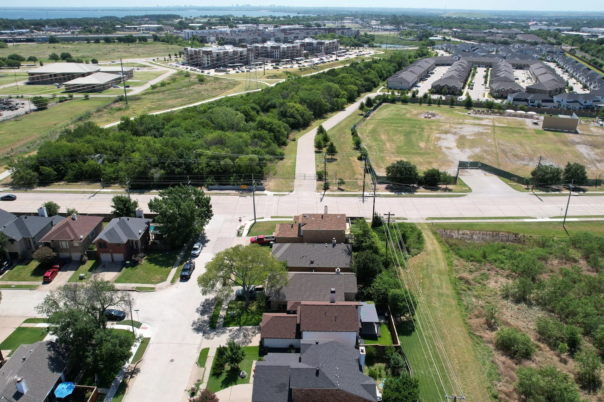 Aerial perspective showcasing a residential street with single-family homes, green spaces, and community infrastructure