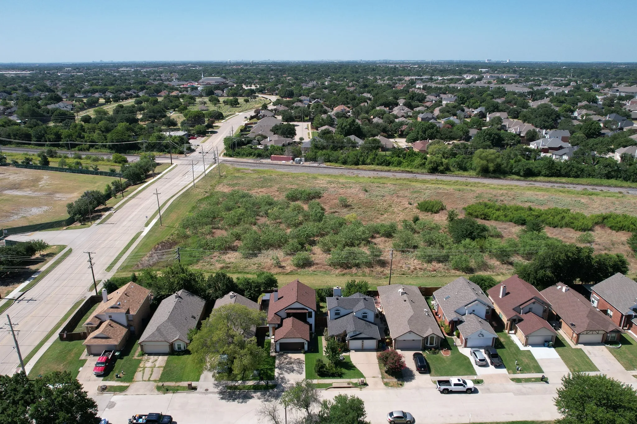 Aerial perspective showcasing a residential street with single-family homes and mature trees