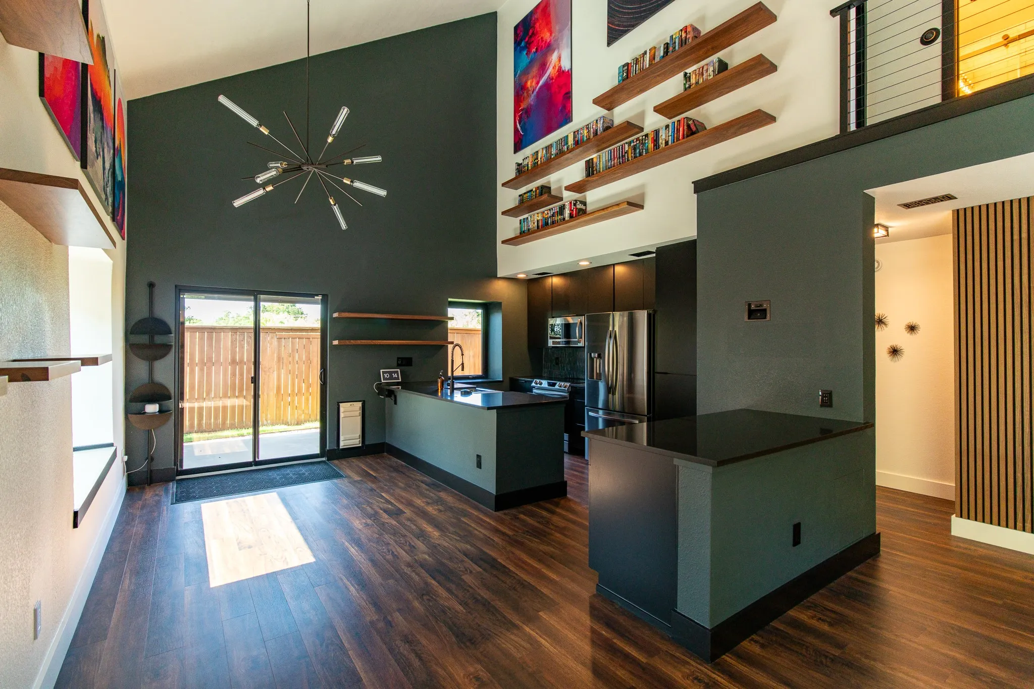 Vaulted ceilings featuring a contemporary chandelier and high-mounted shelving