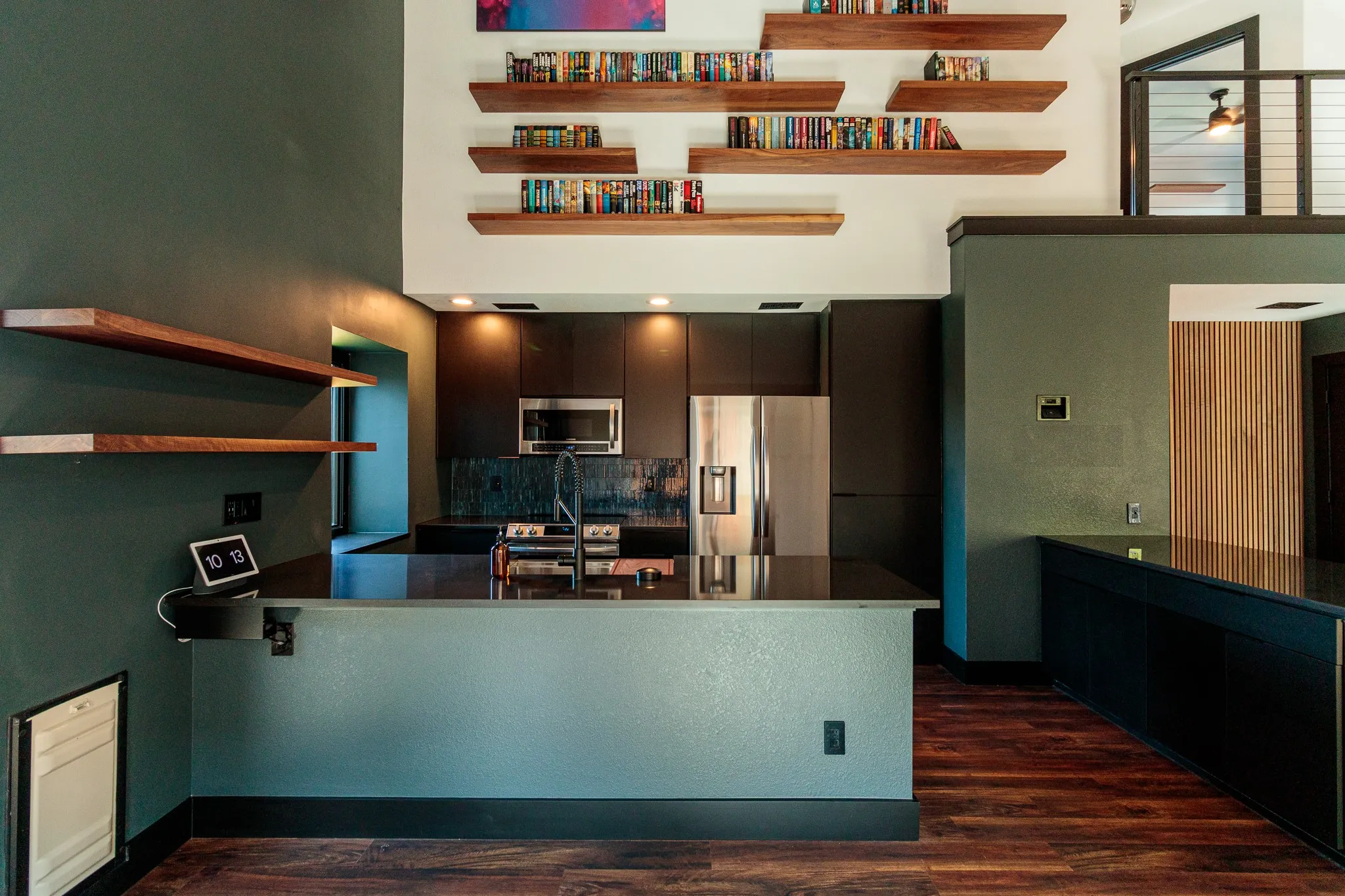 Modern kitchen featuring dark cabinetry, stainless steel appliances, and a dark countertop