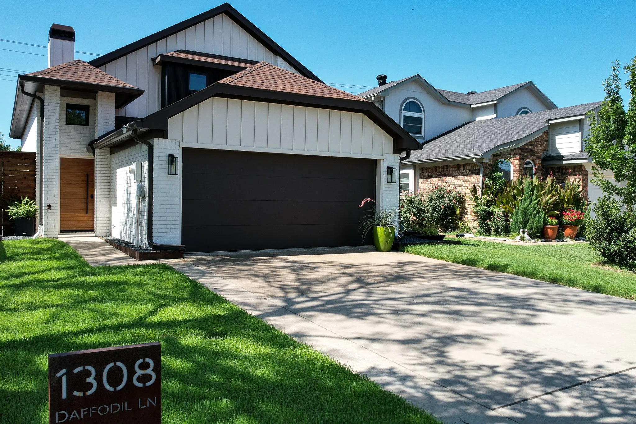 Contemporary two-story exterior featuring white brick and vertical white siding