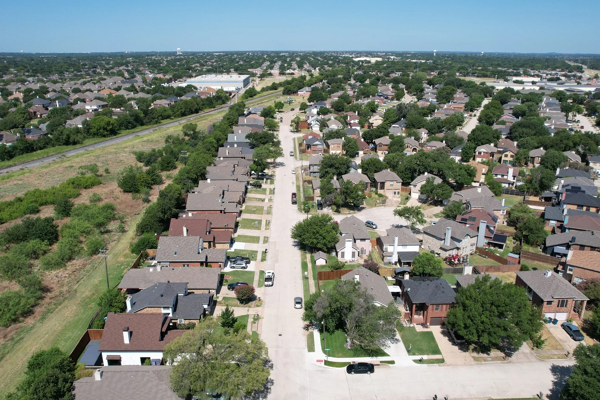 Aerial perspective showcasing a residential neighborhood with a consistent architectural style, as you pull into the neighborhood.