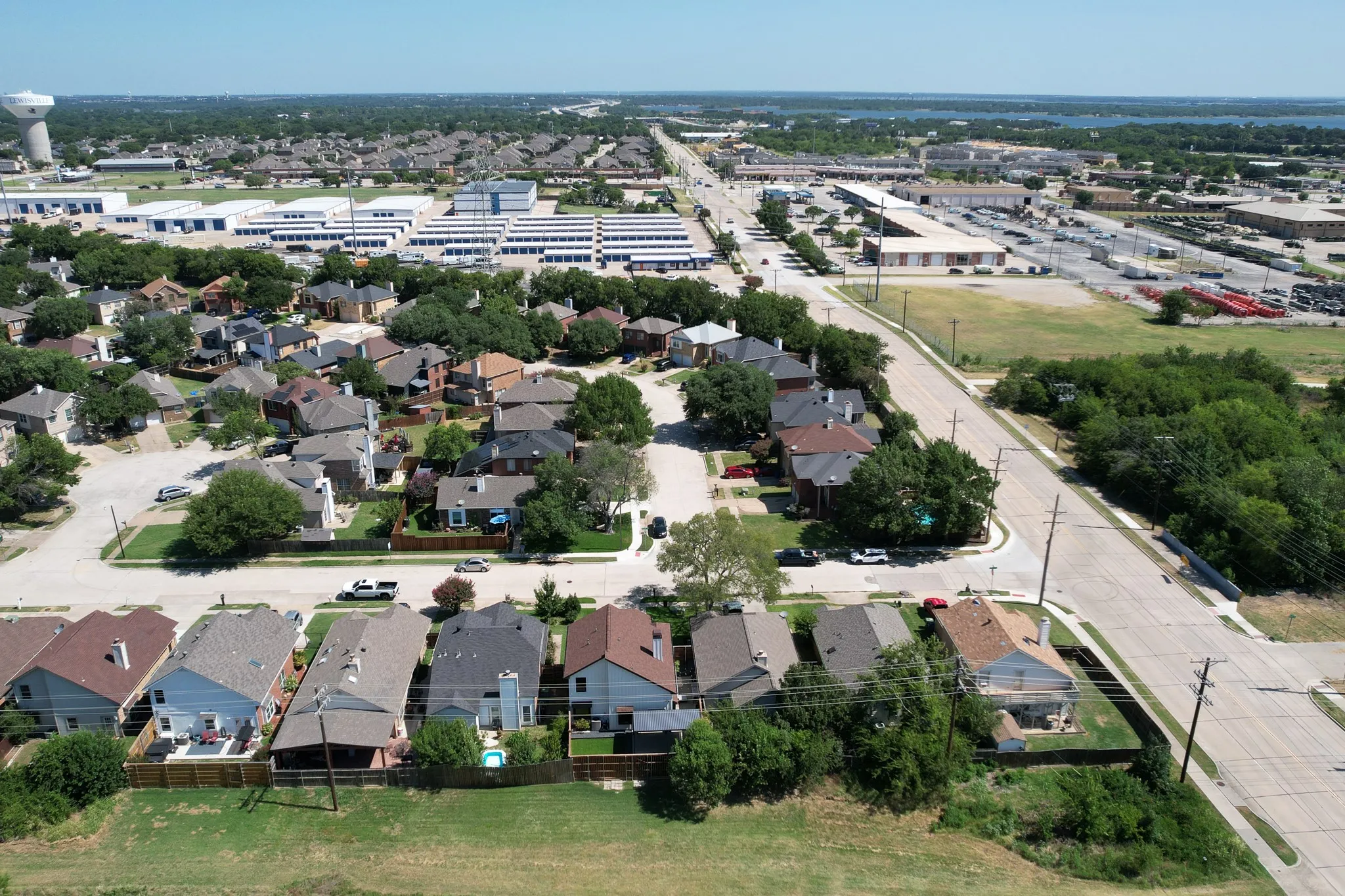 Aerial overview showcasing residential streets, a mix of single-family homes with various rooflines, and mature trees