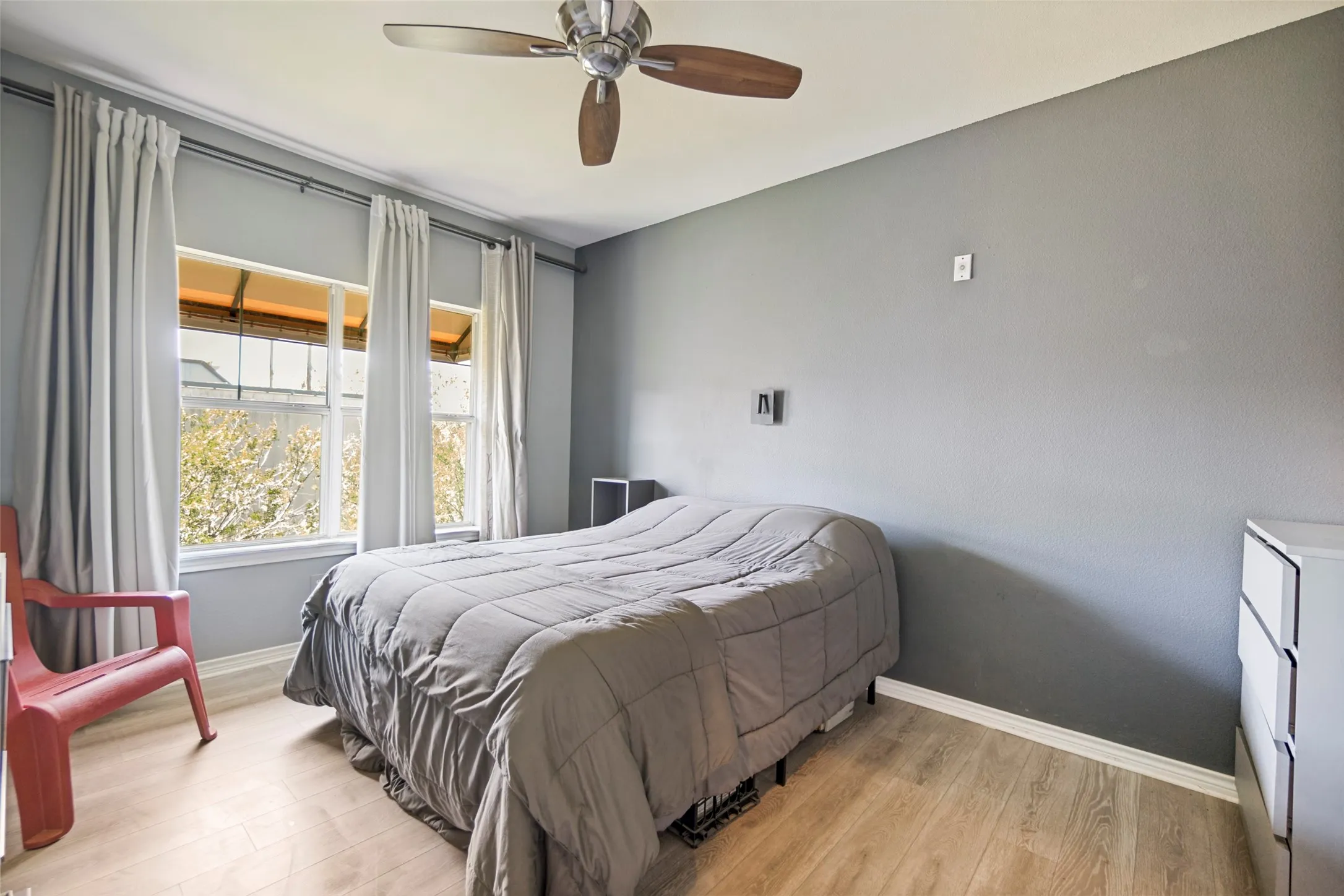 BEDROOM WITH LOTS OF NATURAL LIGHT AND A CEILING FAN