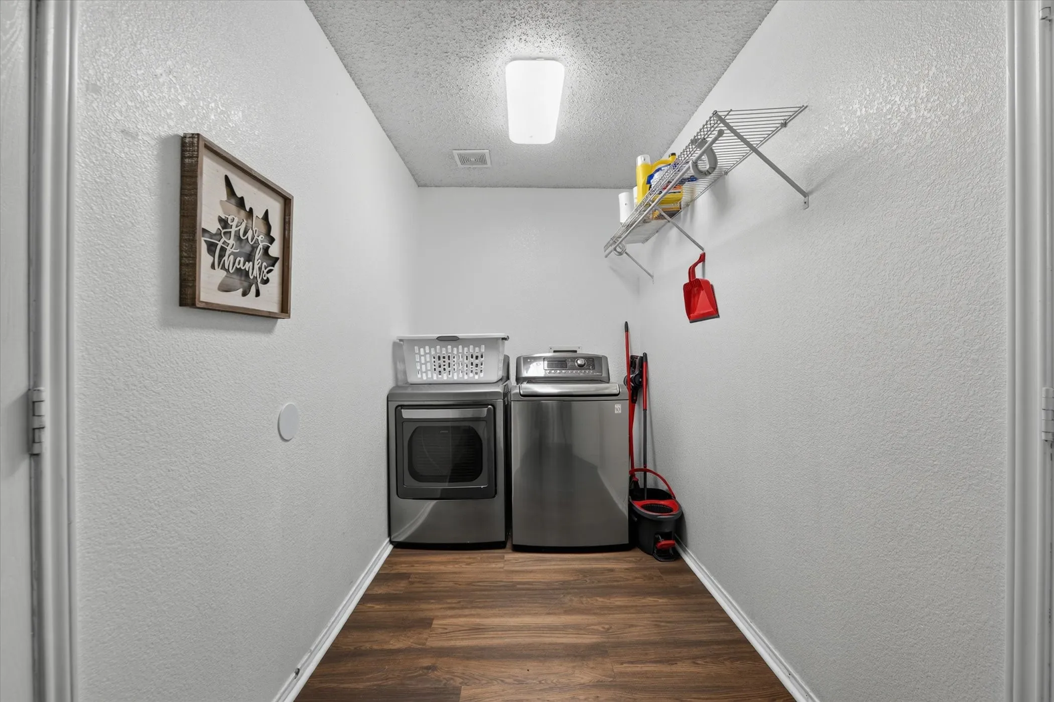 Dedicated laundry area featuring wood-finish flooring, light gray walls, and a recessed ceiling light