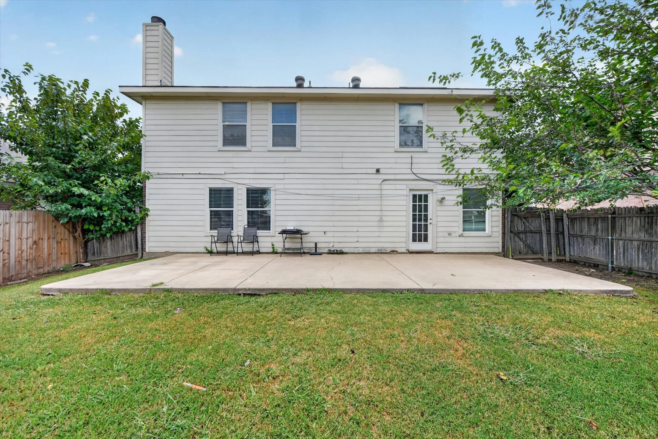 Two-story exterior with horizontal siding and a large concrete patio
