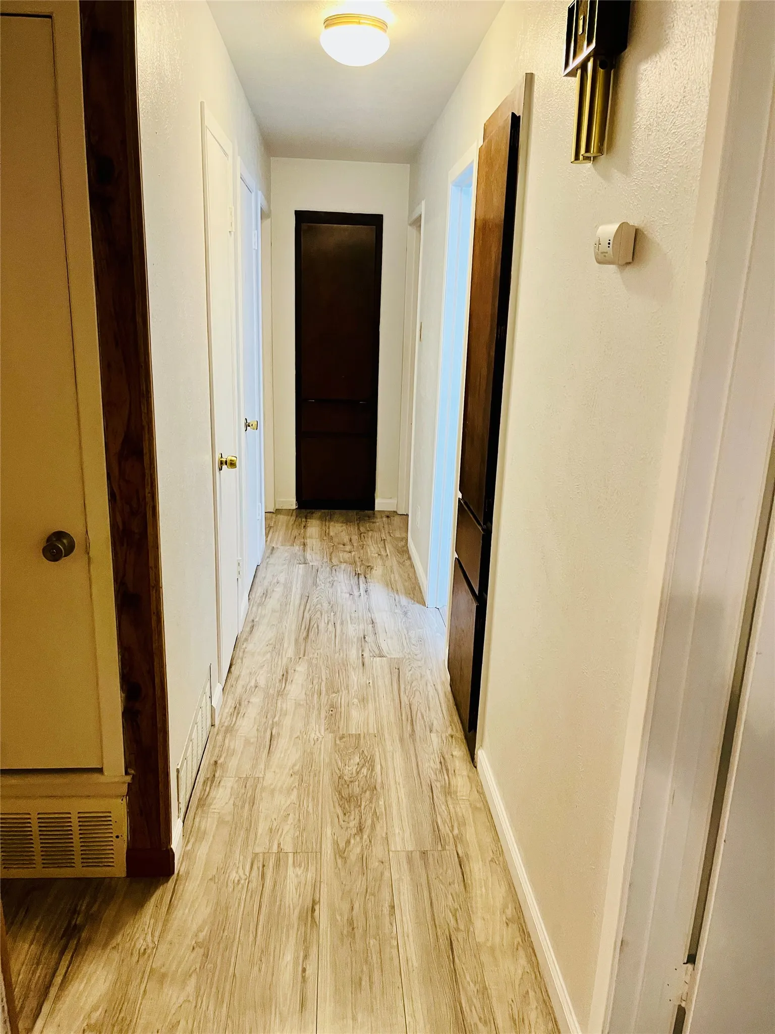 Hallway featuring wood-finish flooring