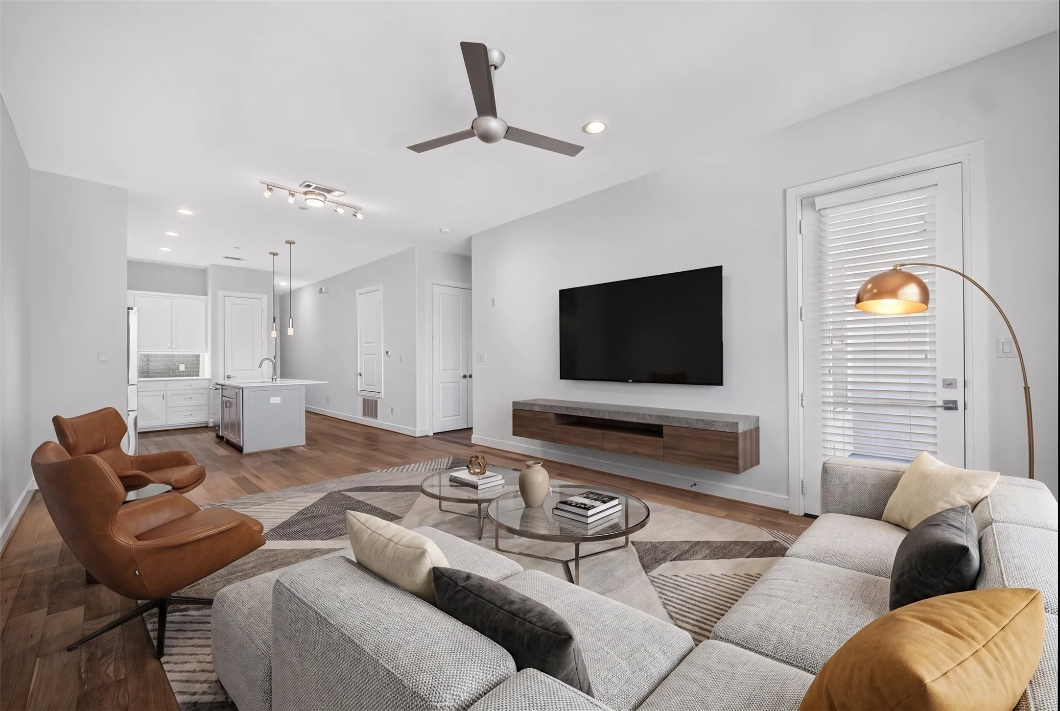 Open-concept living area featuring wood-finish flooring and a contemporary ceiling fan