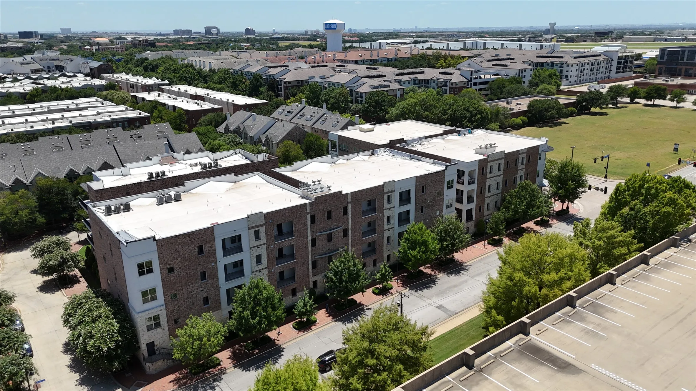 Contemporary apartment building featuring brick and stone facades, private balconies, and landscaped grounds