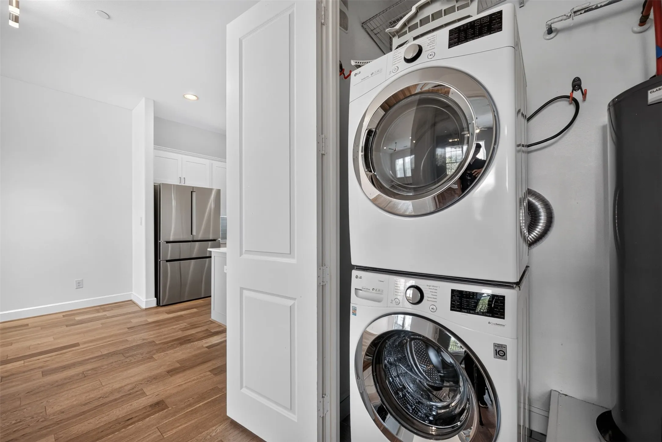 Dedicated laundry closet featuring a stacked white washer and dryer unit