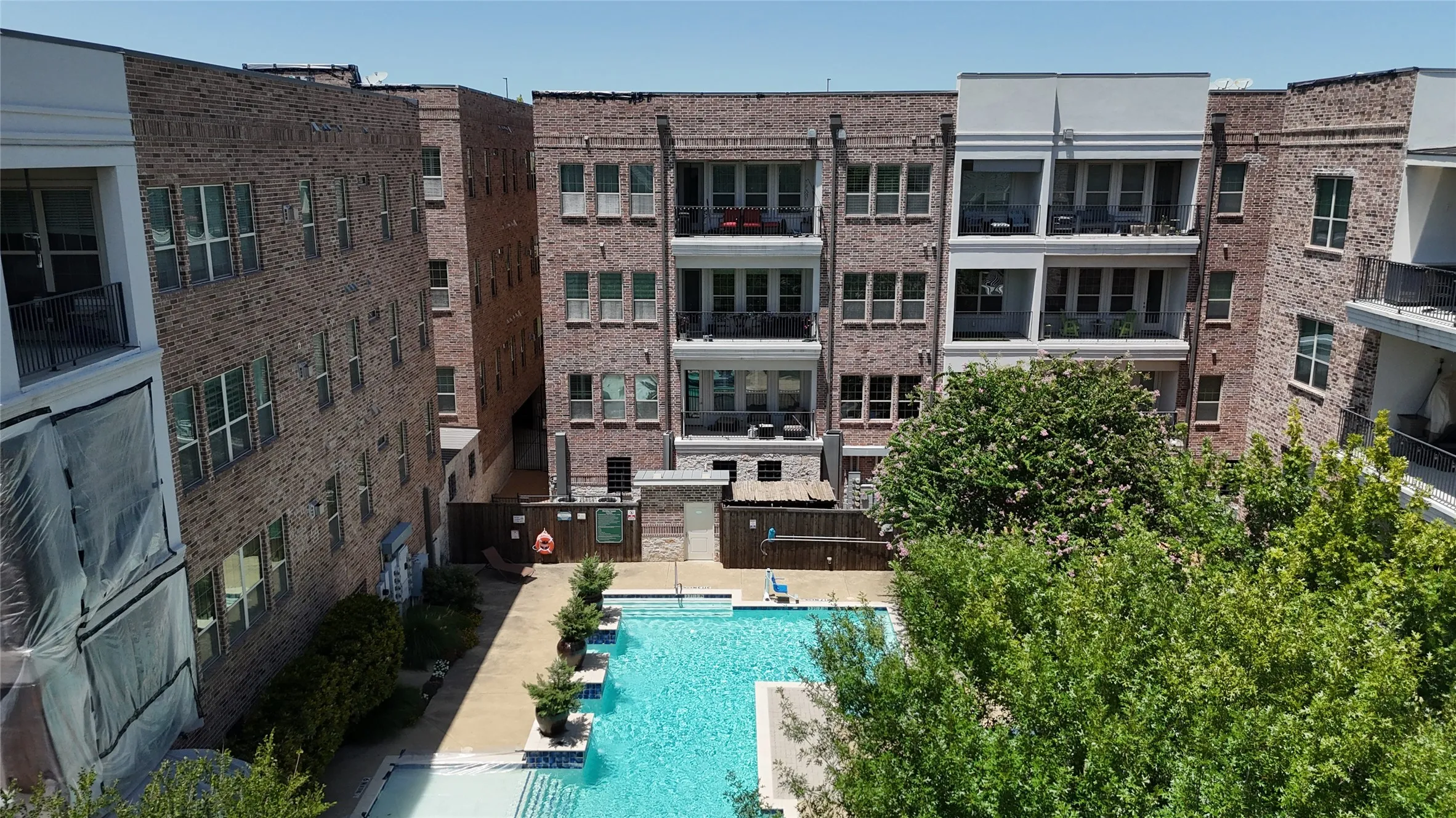 Central swimming pool with a surrounding hardscape patio