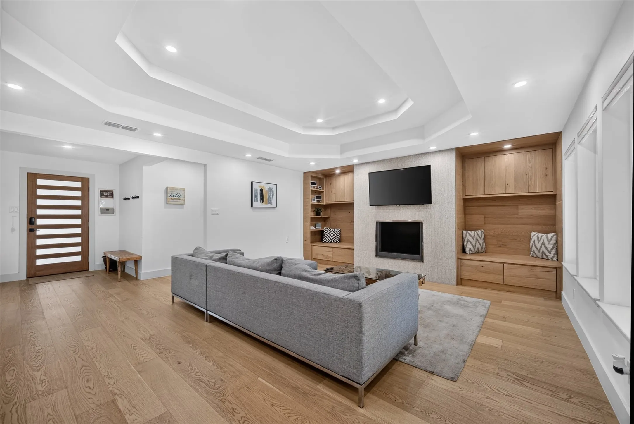Hardwood-finish flooring extending throughout, complemented by a tray ceiling with recessed lighting