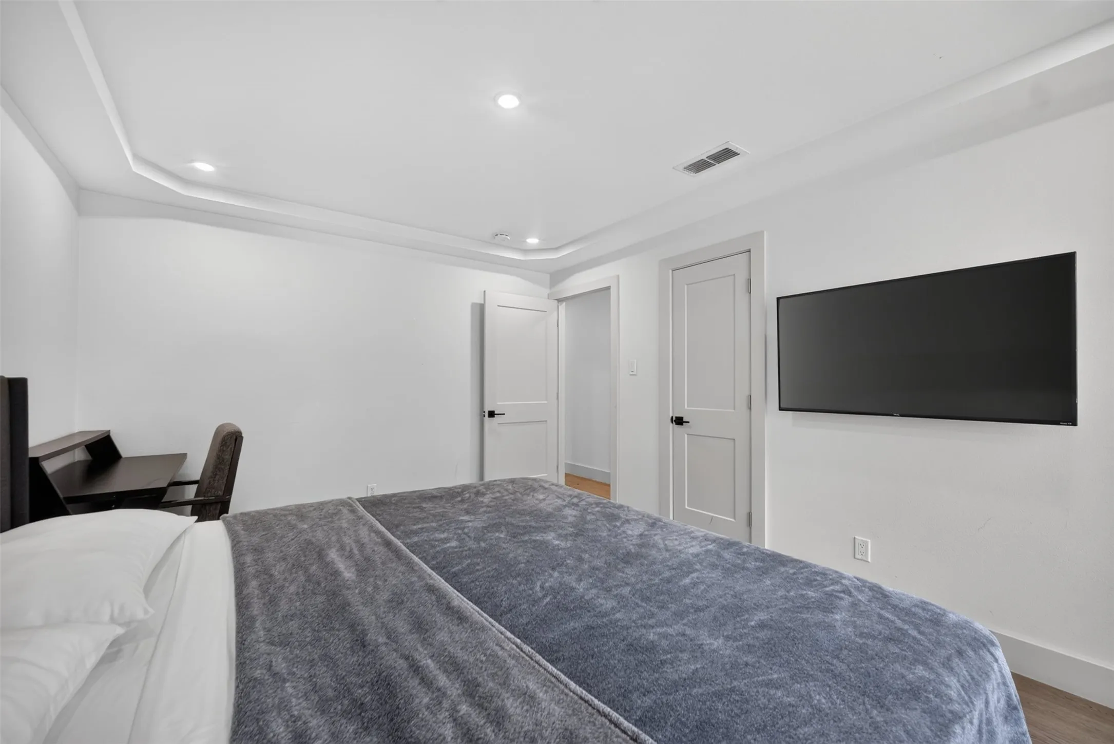 Room featuring recessed lighting, a tray ceiling, and hard surface flooring