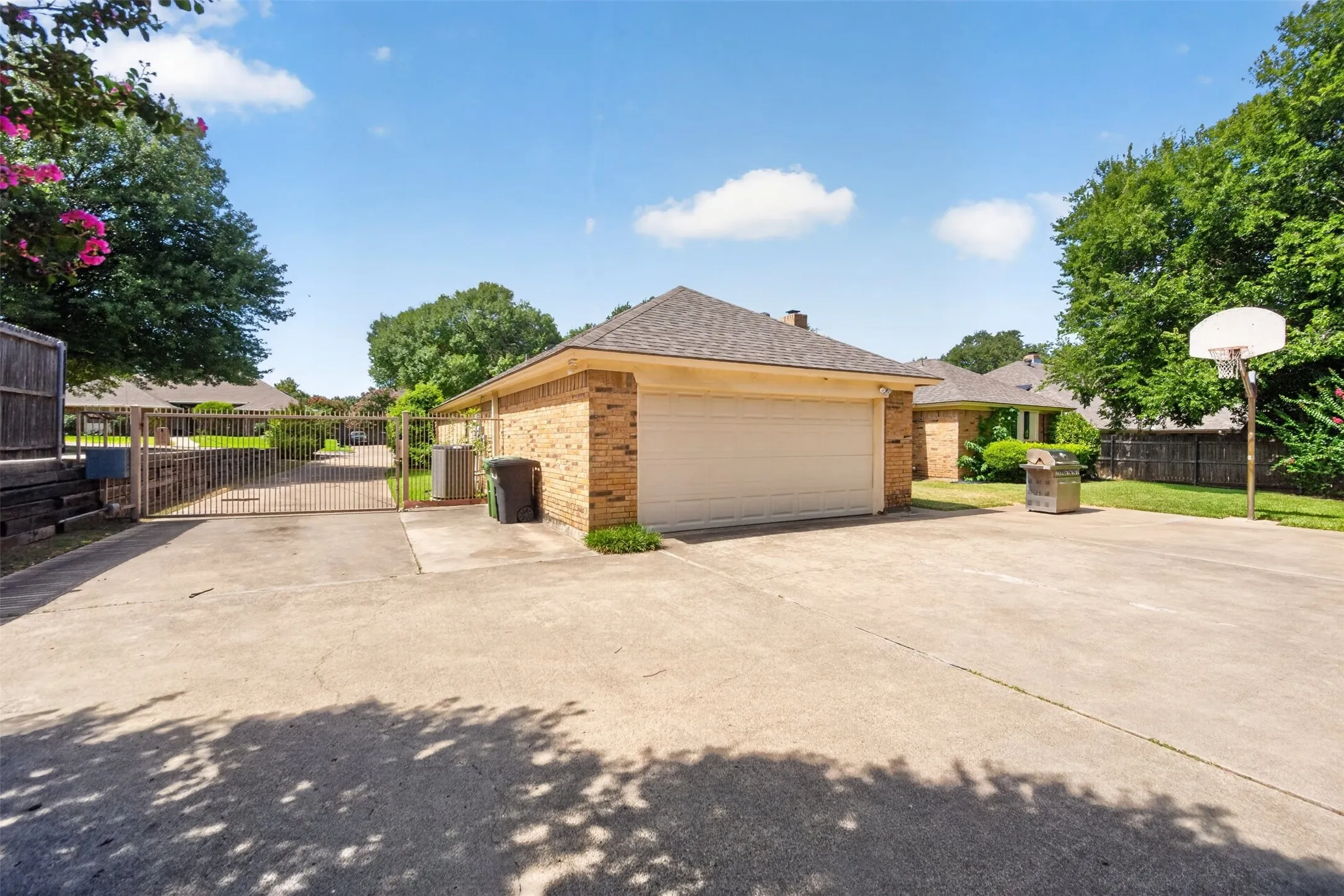 Concrete driveway with an integrated basketball hoop and a brick garage structure