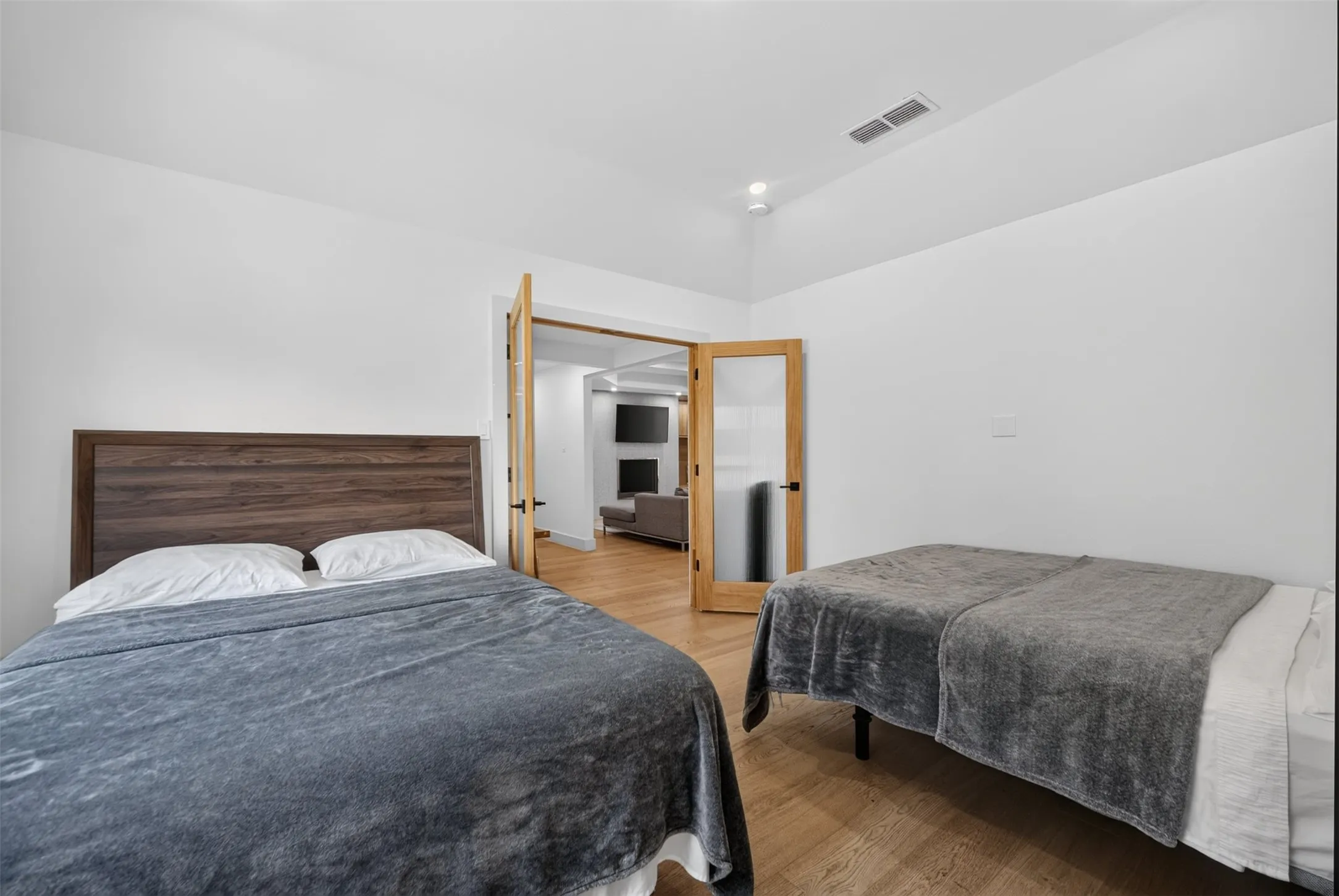 Interior room with wood-finish flooring, white walls, and a recessed lighting fixture