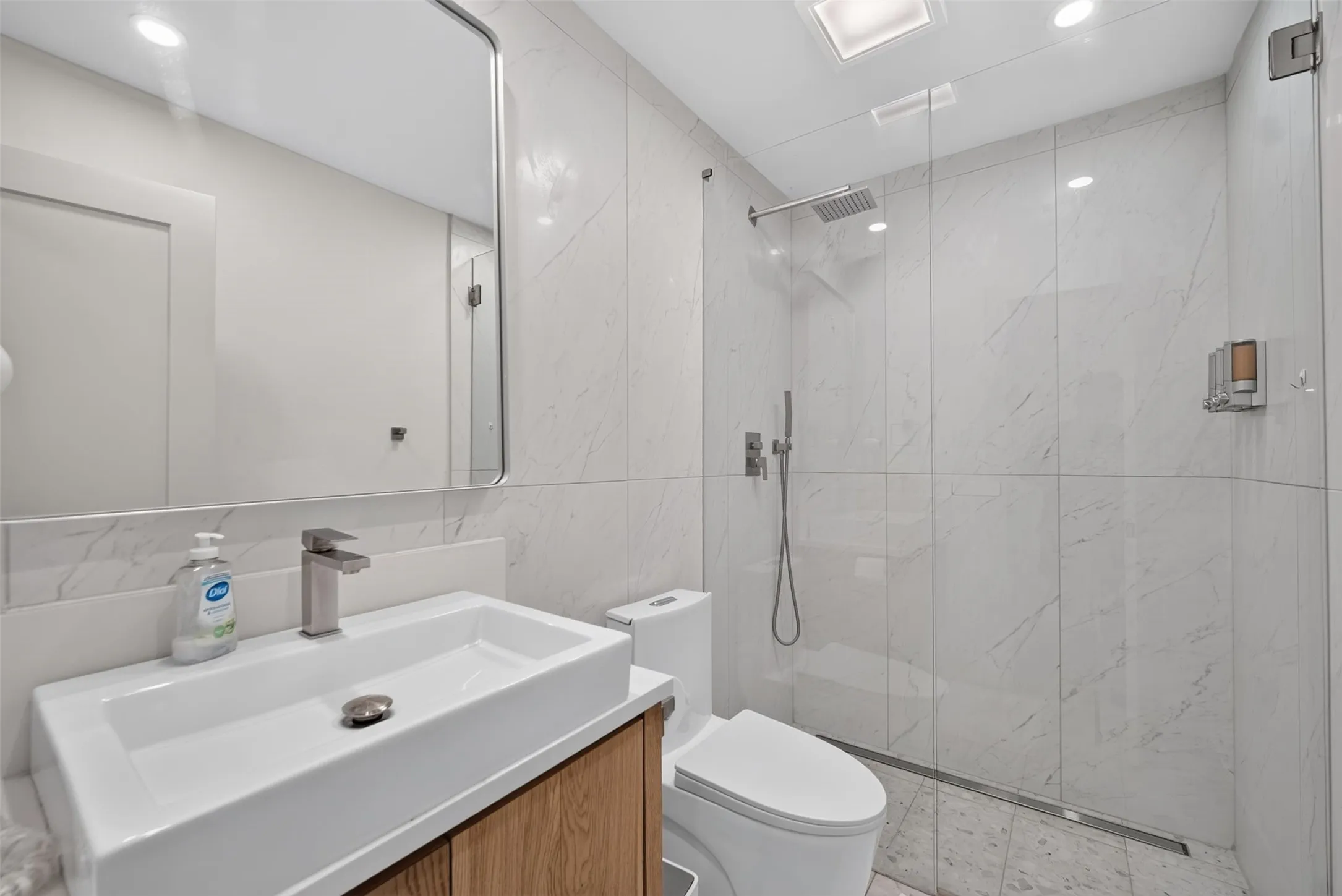 Contemporary bathroom featuring a floating wood-finish vanity with an integrated rectangular sink