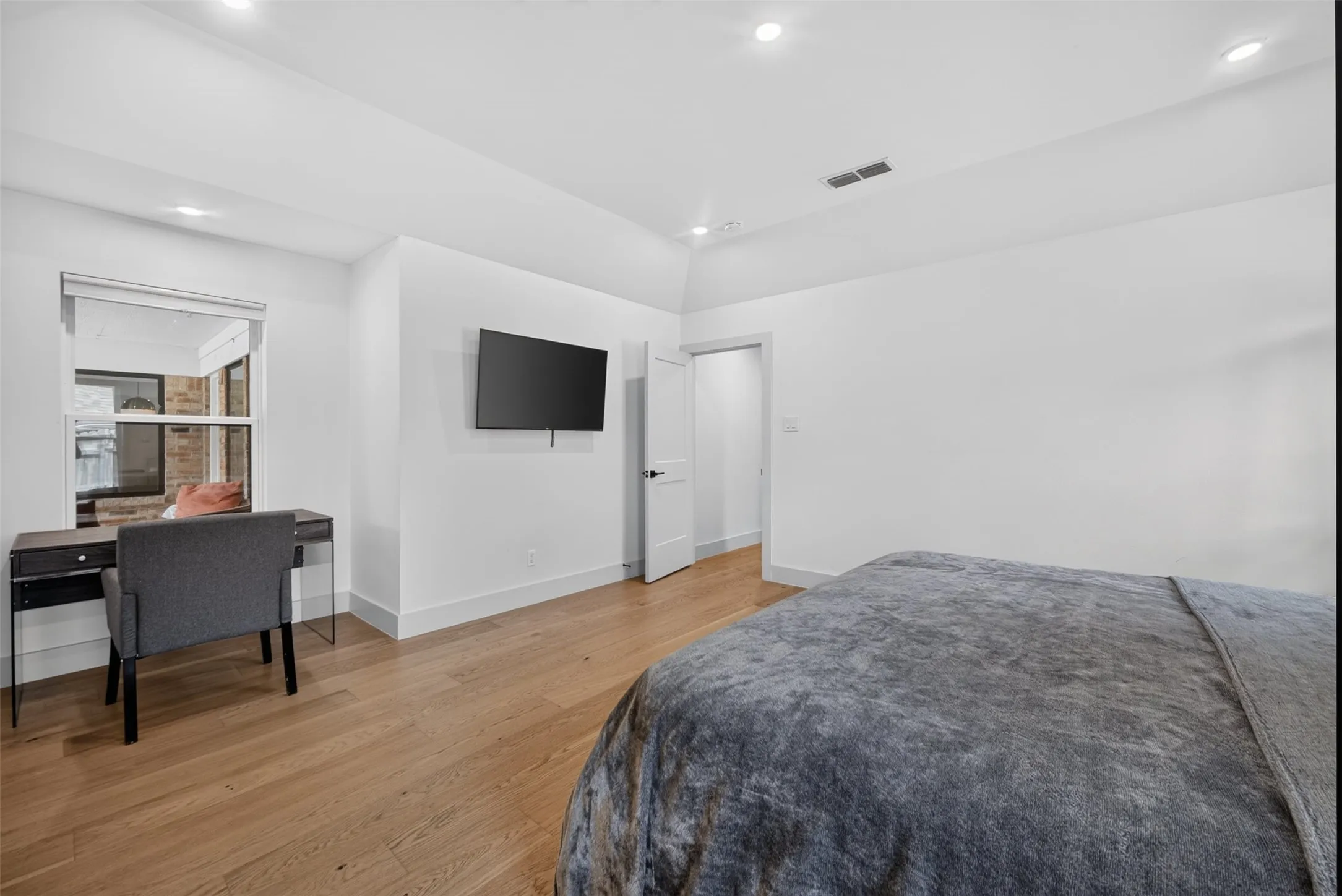Hardwood-style flooring throughout this bright room with recessed lighting