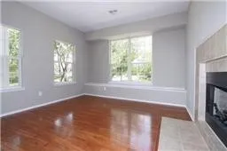 Unfurnished living room with a fireplace with flush hearth, healthy amount of natural light, and wood finished floors