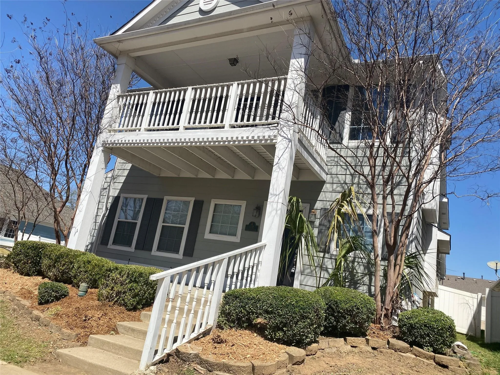 Shotgun-style home featuring a balcony, stairs, and a porch