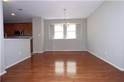 Unfurnished living room with a chandelier and wood finished floors