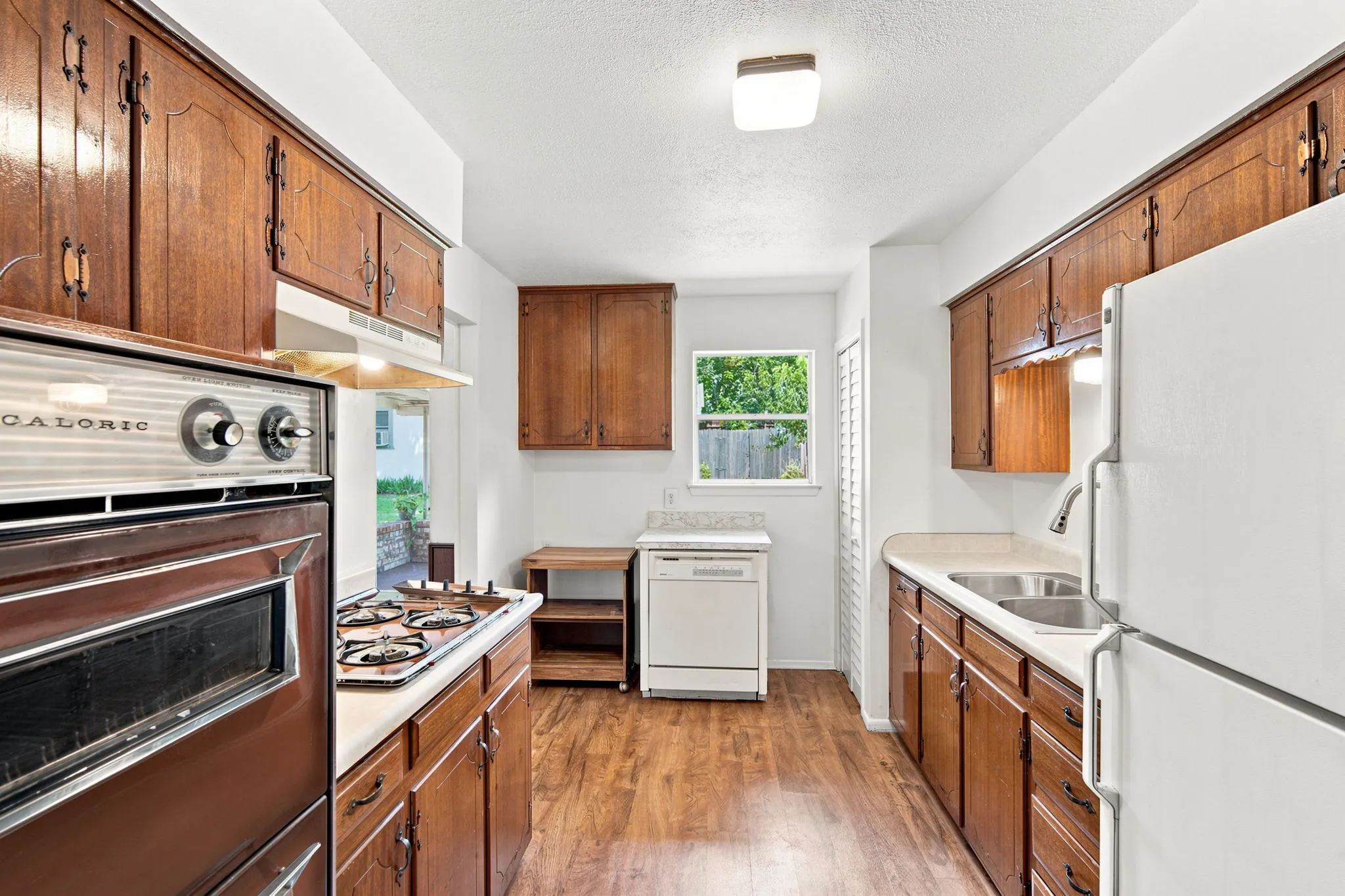 Kitchen featuring wood-finish flooring and ample cabinetry